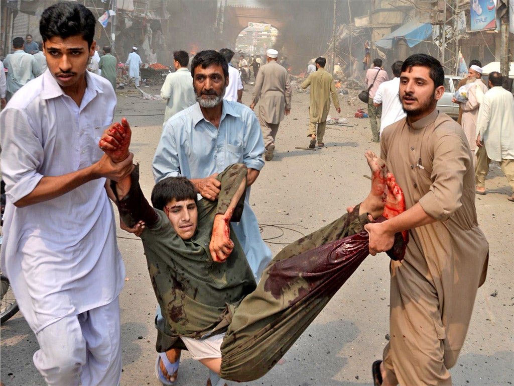 A blast victim is carried from the scene of a bomb explosion in the busy Kissa Khwani market in Peshawar, on September 29