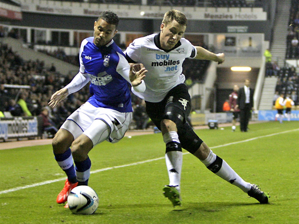 Ipswich’s Carlos Edwards is closed down by Craig Forsyth of Derby