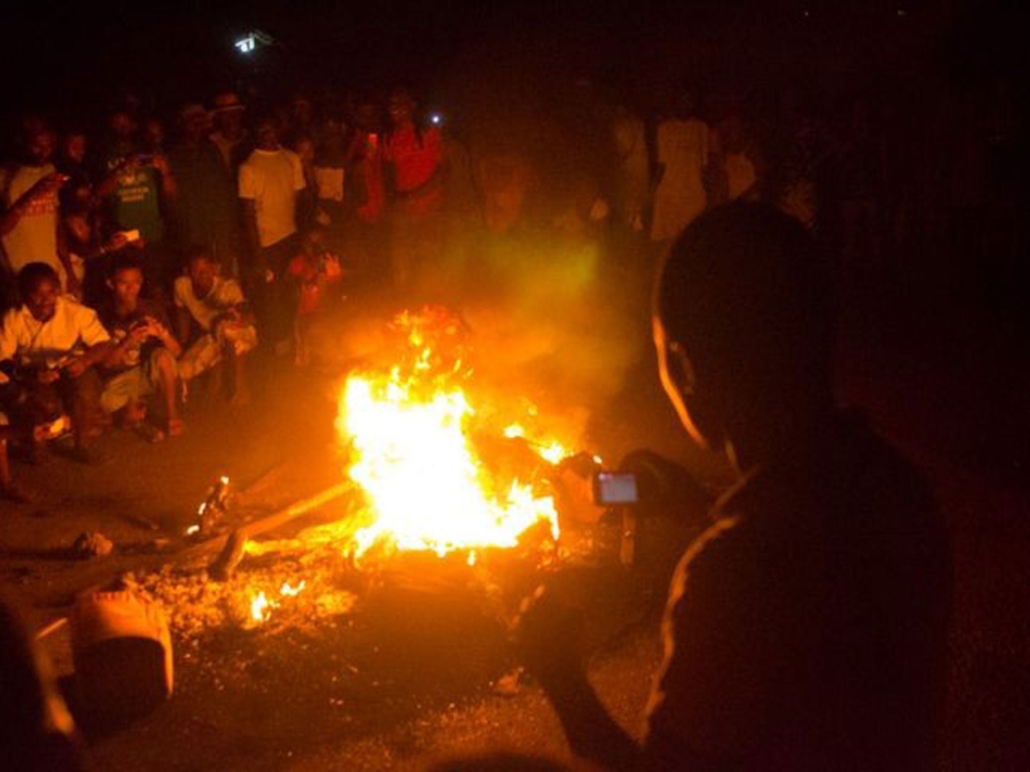 Onlookers take pictures of the pyre