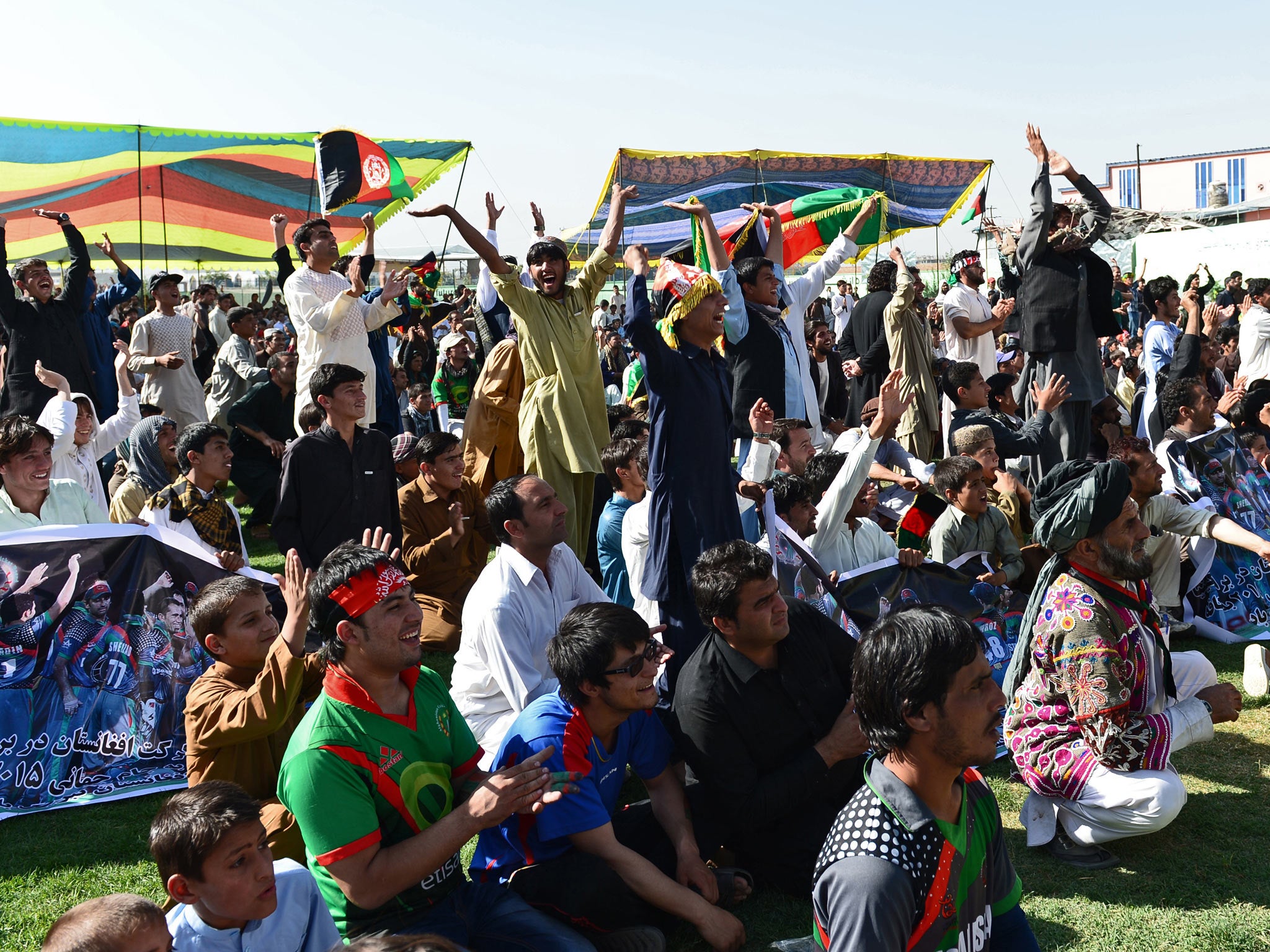 Afghan cricket fans celebrate runs by their team as they watch the Afghanistan and Kenya match on a screen at the International Cricket Stadium in Kabul (Getty Images)