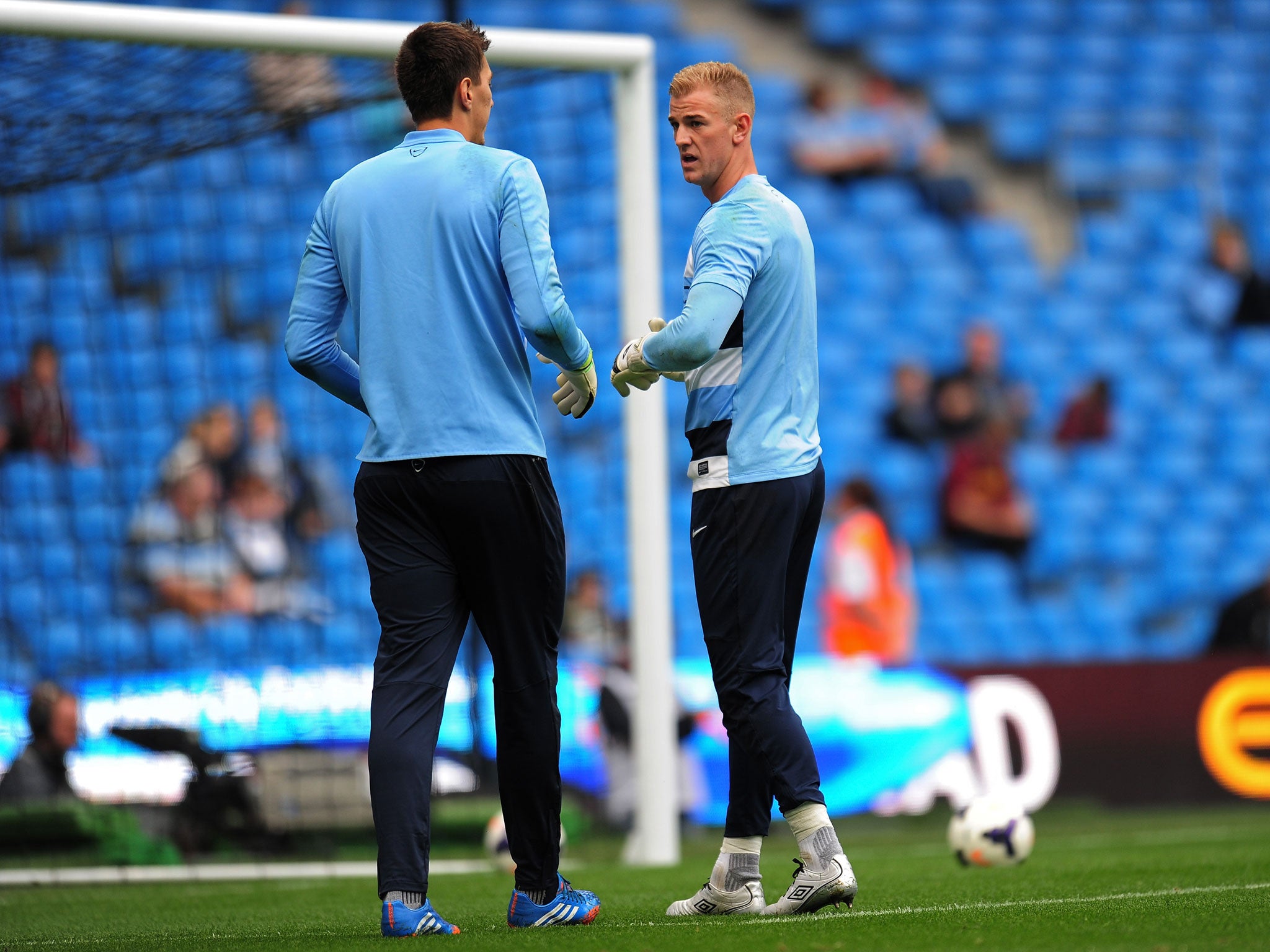 The man in the spotlight, Joe Hart, warms up with fellow keeper Costel Pantilimon