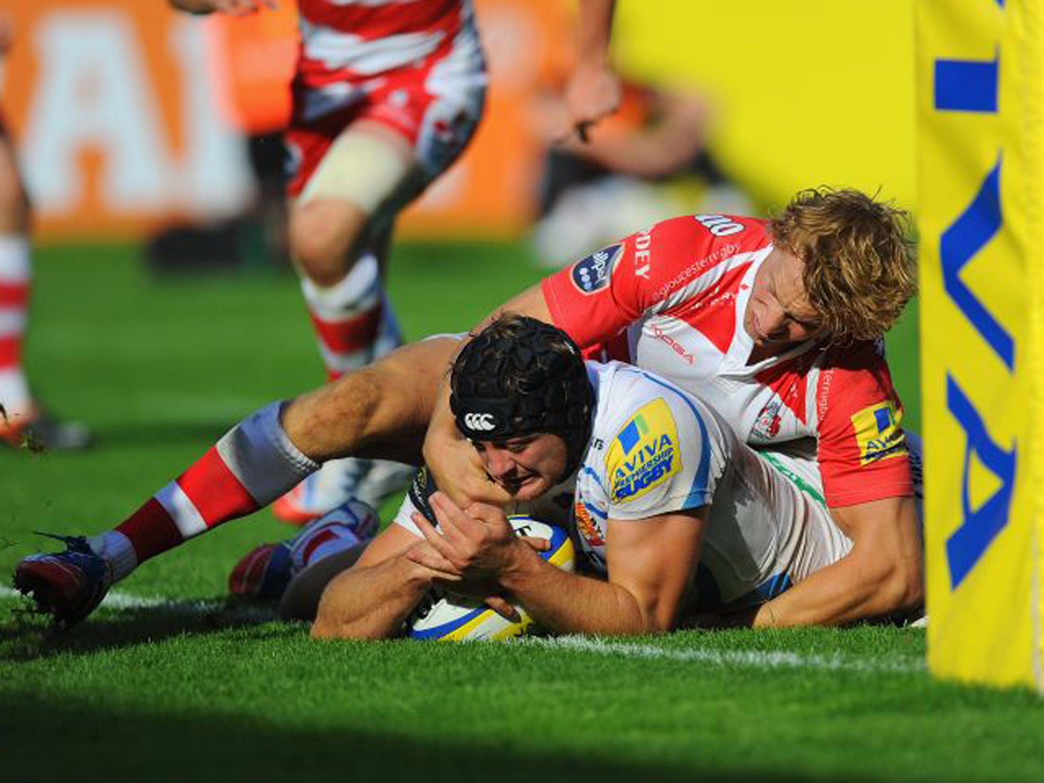 Billy Twelvetrees, of Gloucester, cannot stop Dean Mumm scoring for Exeter