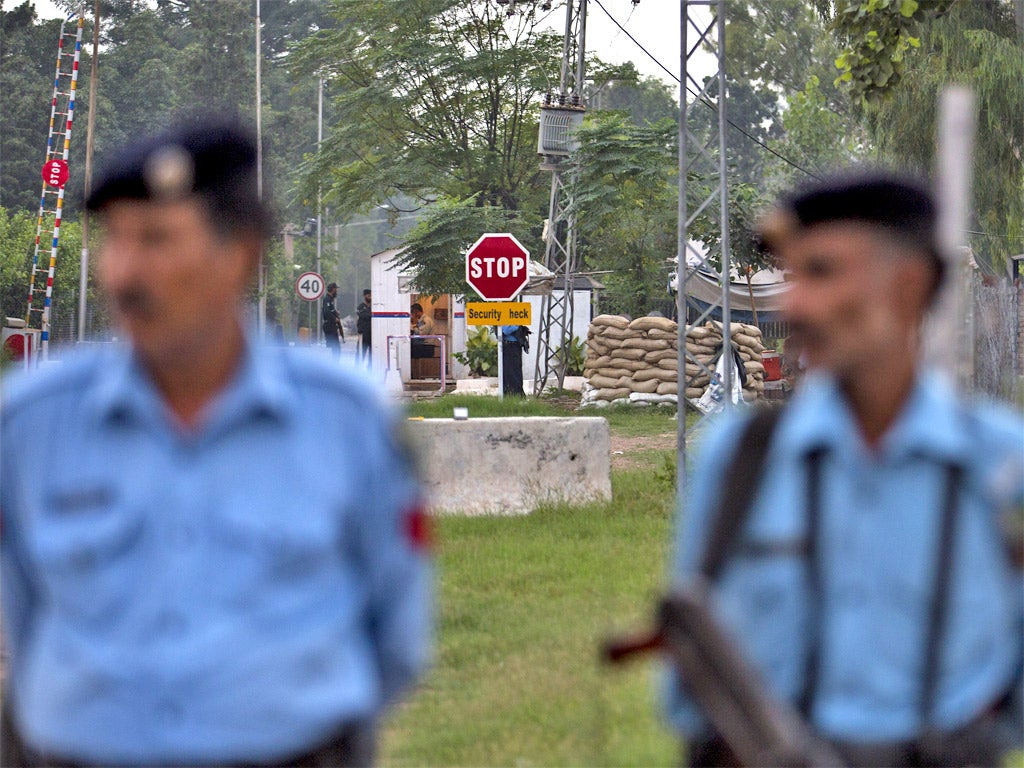 Police officers outside the home Pervez Musharraf, where he has been held under house arrest