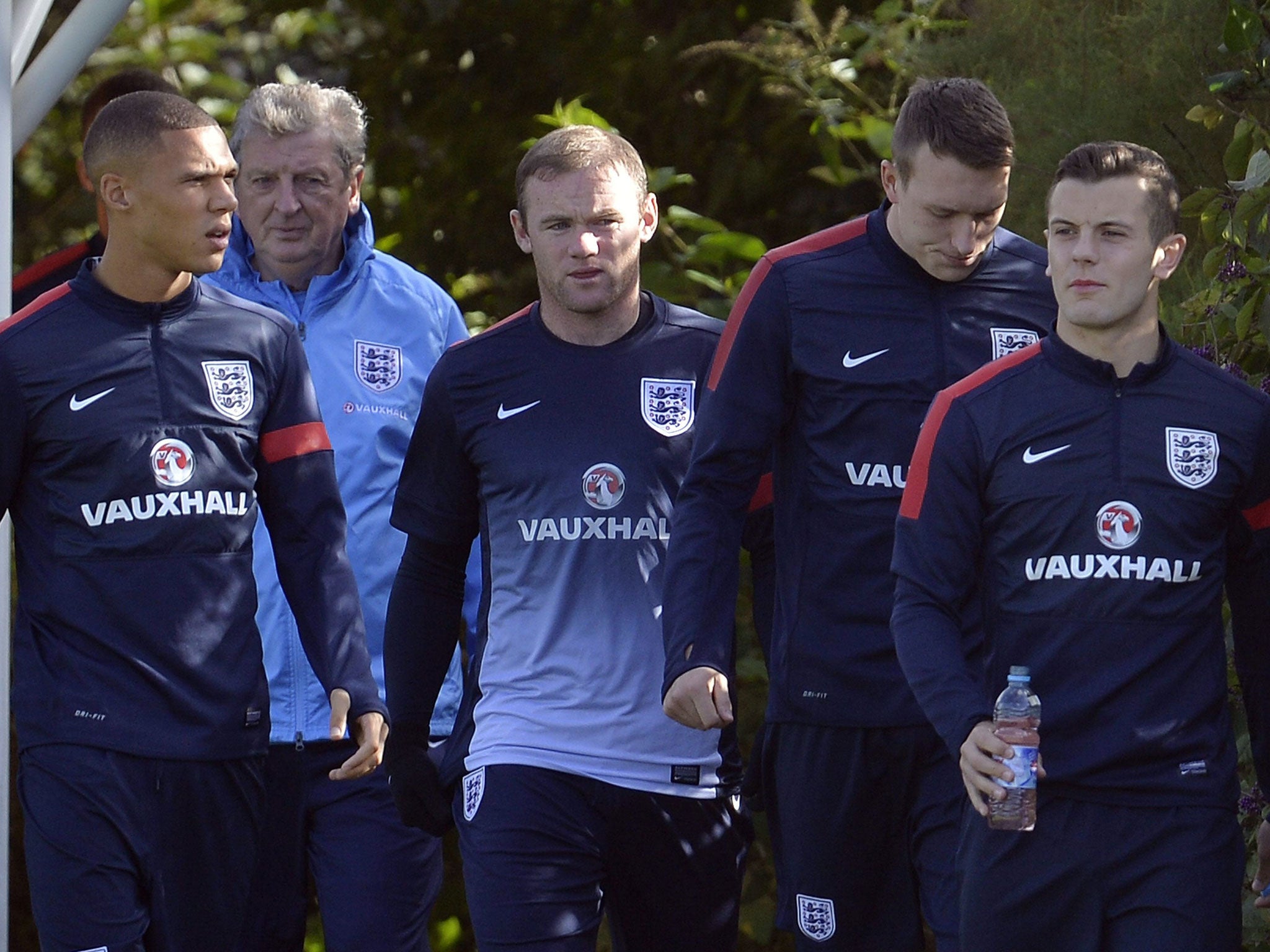 The England manager, Roy Hodgson (second left), looks on as players (from left) Kieran Gibbs, Wayne Rooney, Phil Jones and Jack Wilshere head out for training at London Colney