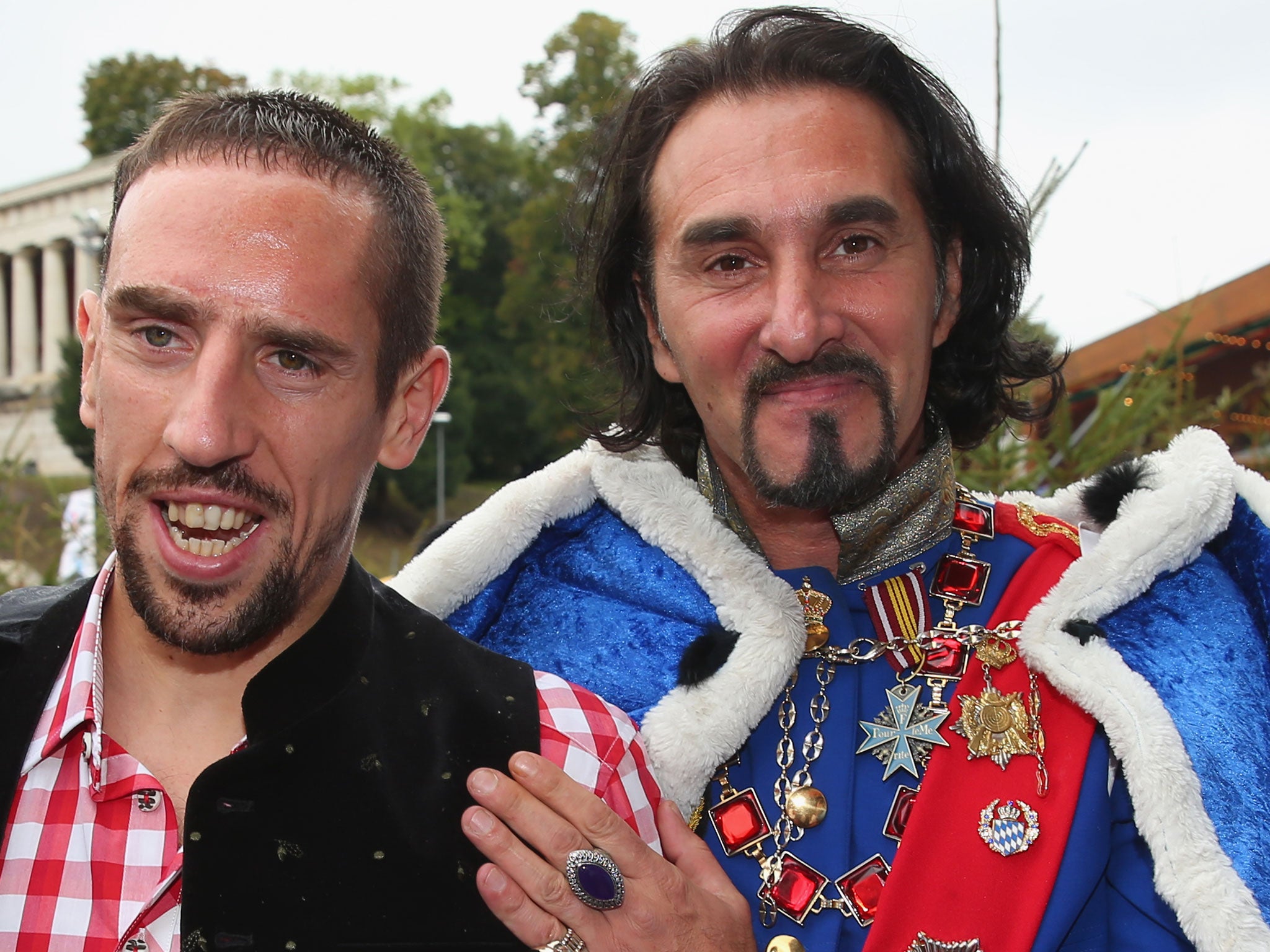 Franck Ribery of Bayern Muenchen poses with a double of former Bavarian King Ludiwig 2nd in front of the ensemble of the Bavaria statue, a monumental bronze sand-cast 19th-century statue and the Hall of Fame