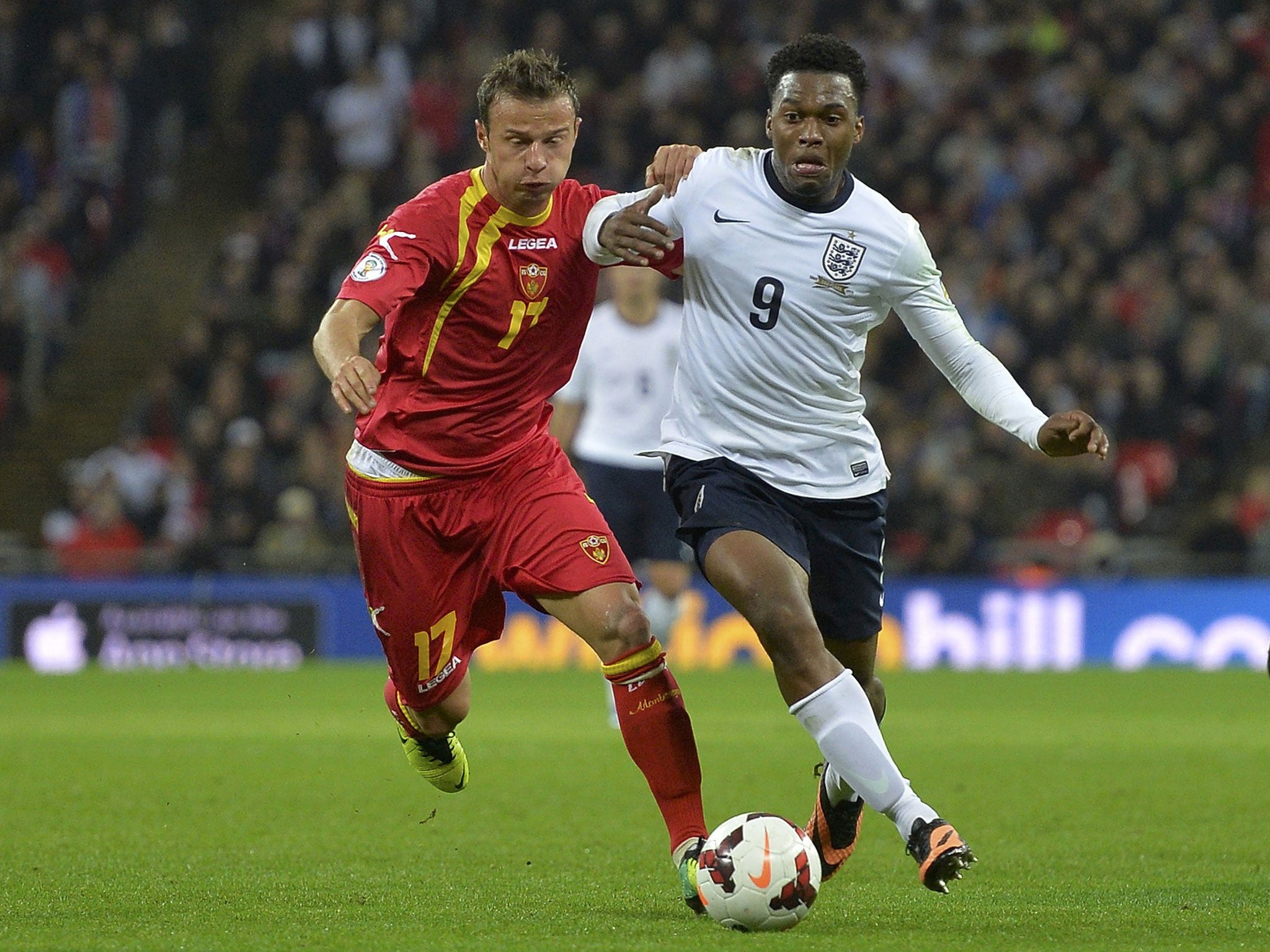 Daniel Sturridge, left, takes on Elsad Zverotic, right, of Montenegro, at Wembley