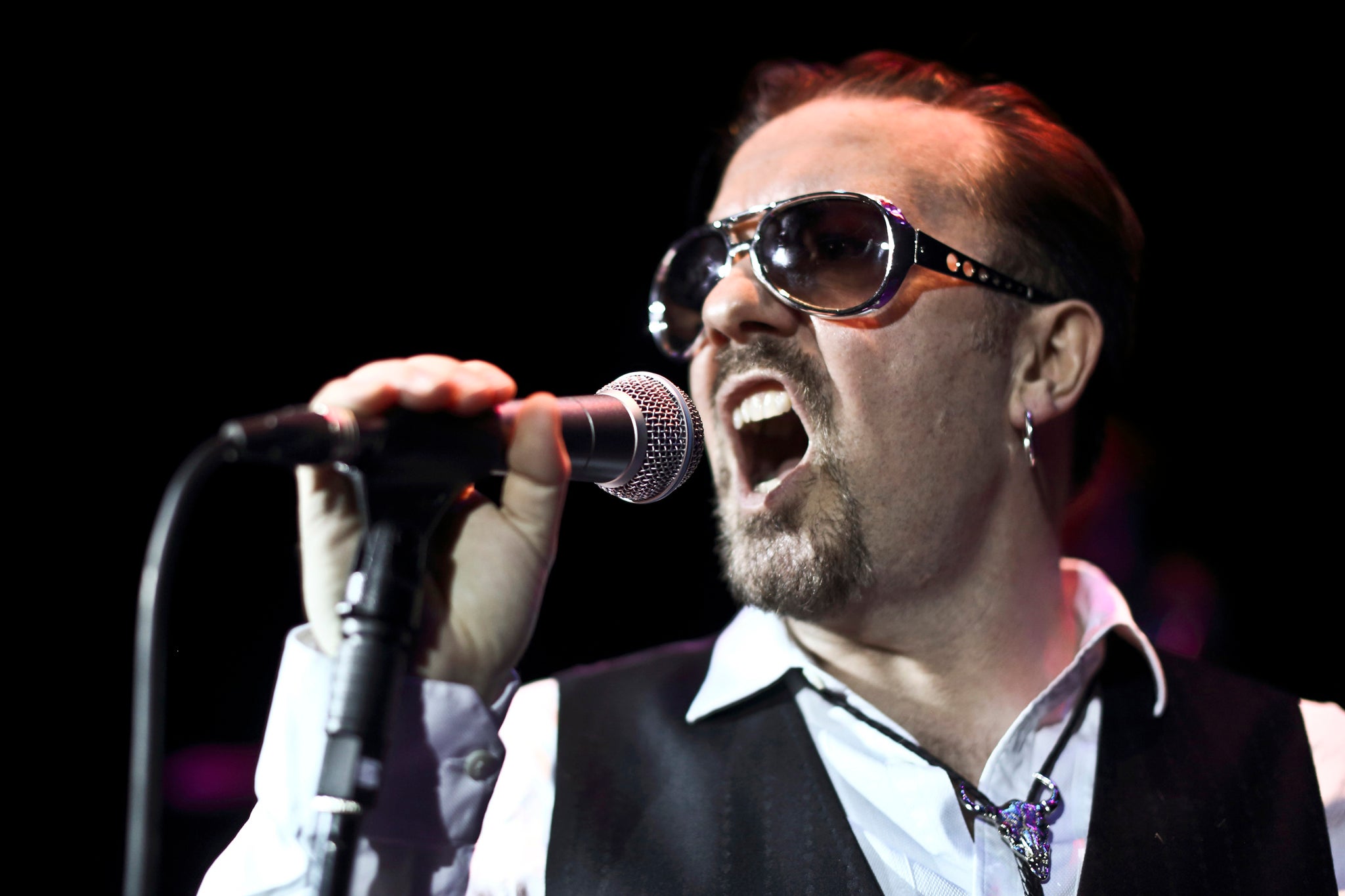 Ricky Gervais on stage in character as aspiring rock star David Brent