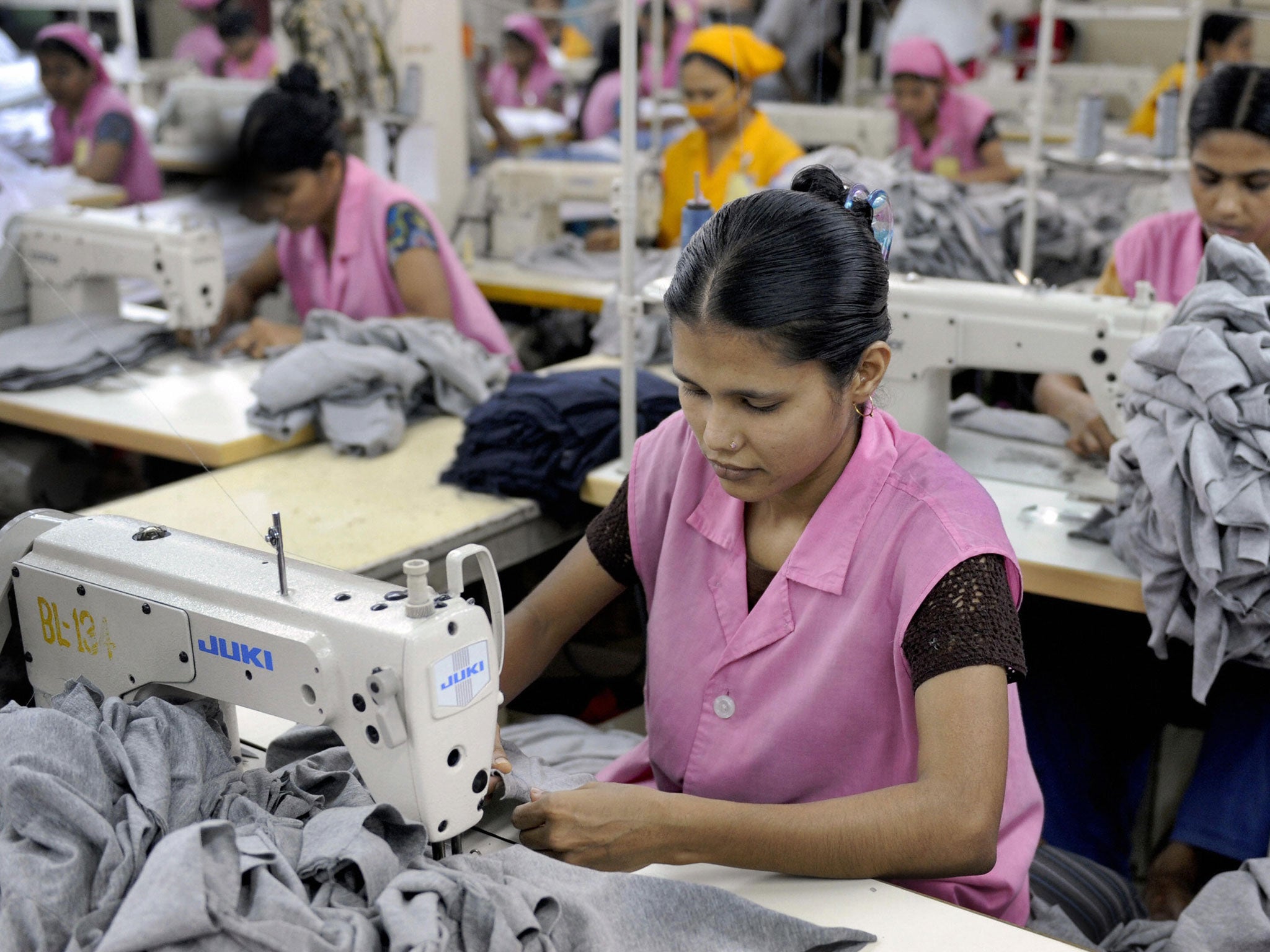 Bangladeshi Garment workers sew T-shirts at a factory in Dhaka on March 18, 2009