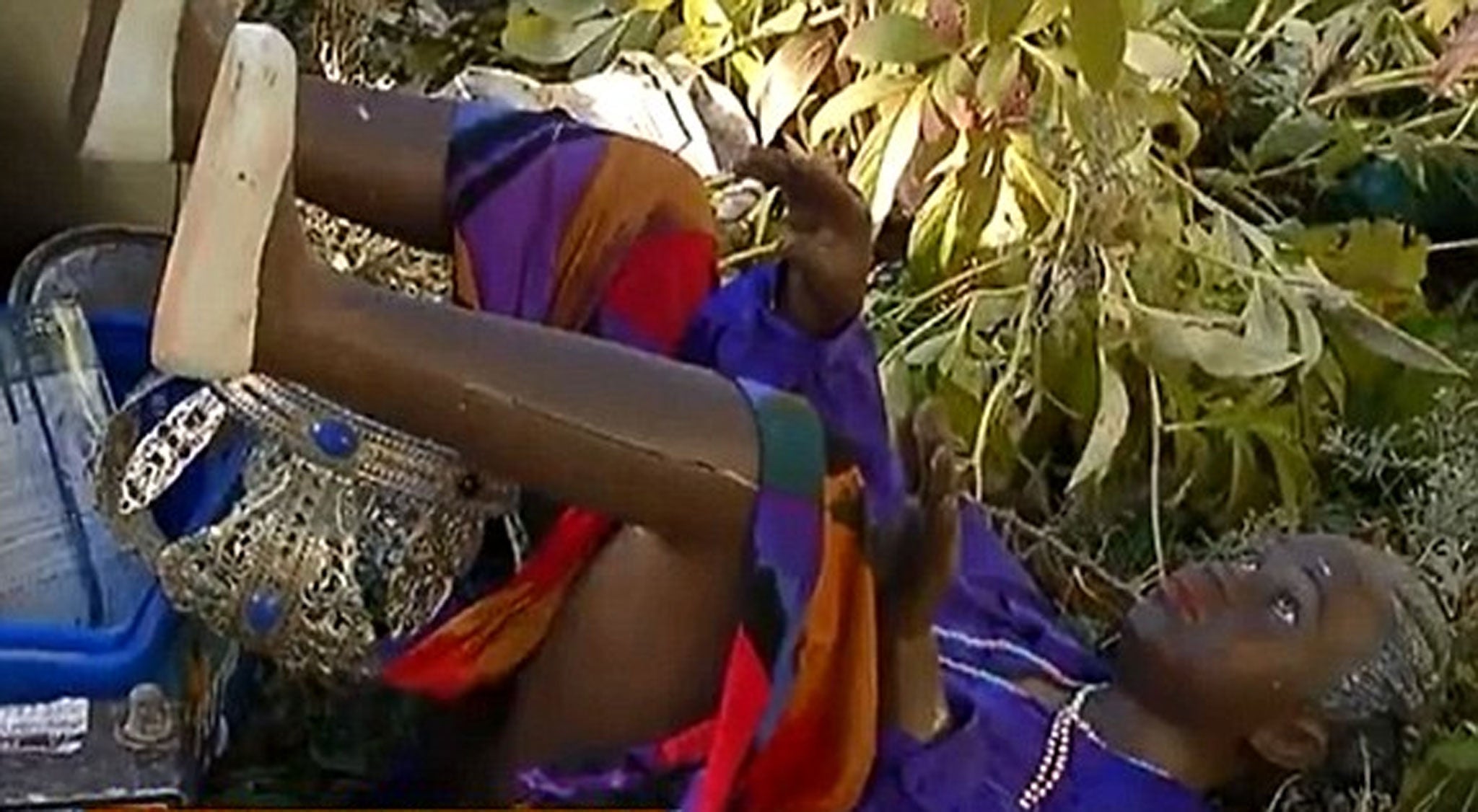 A life size mannequin dressed in purple robes, a beaded necklace and a crown.