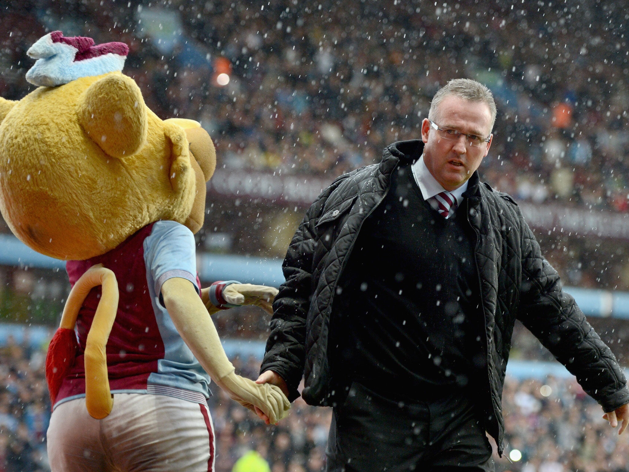 Manager Paul Lambert of Aston Villa shakes hands with the mascot