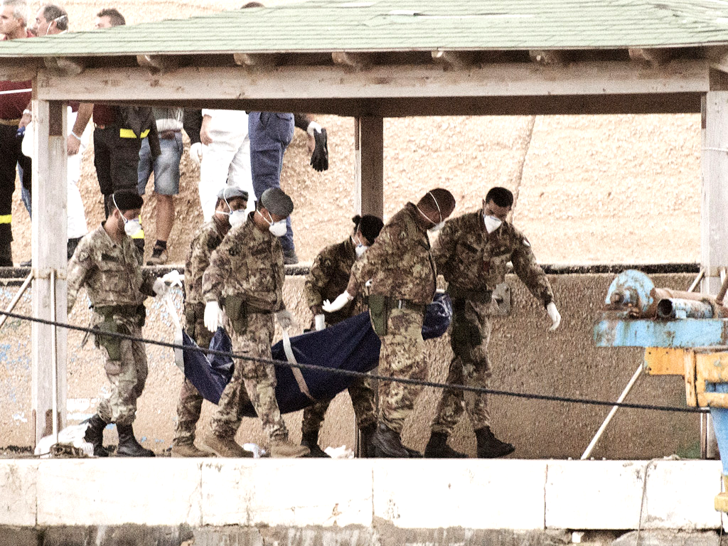 Italian soldiers carry the body of a victim of the ship of immigrants that sank off the coast of Lampedusa