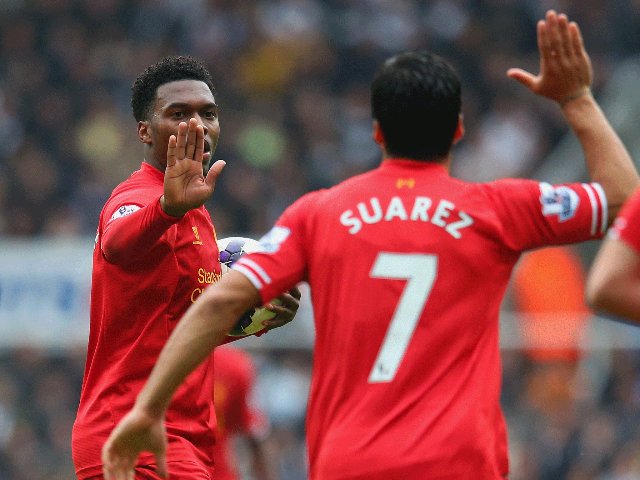 Daniel Sturridge of Liverpool high fives Luis Suarez