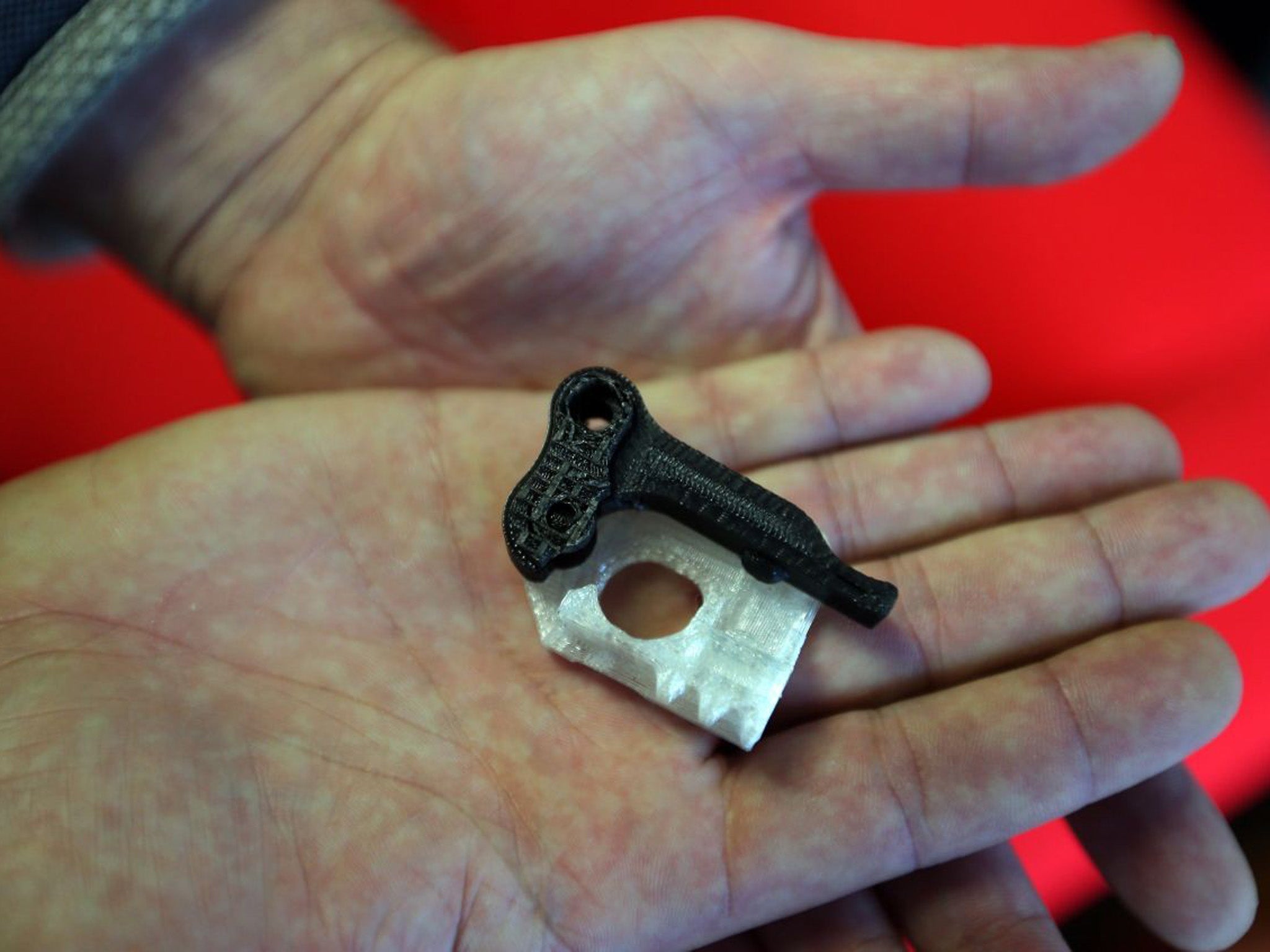 Shop owner 'Andrew' holds parts of what police initially thought was a 3D printed gun, however he claims they are parts of his printer