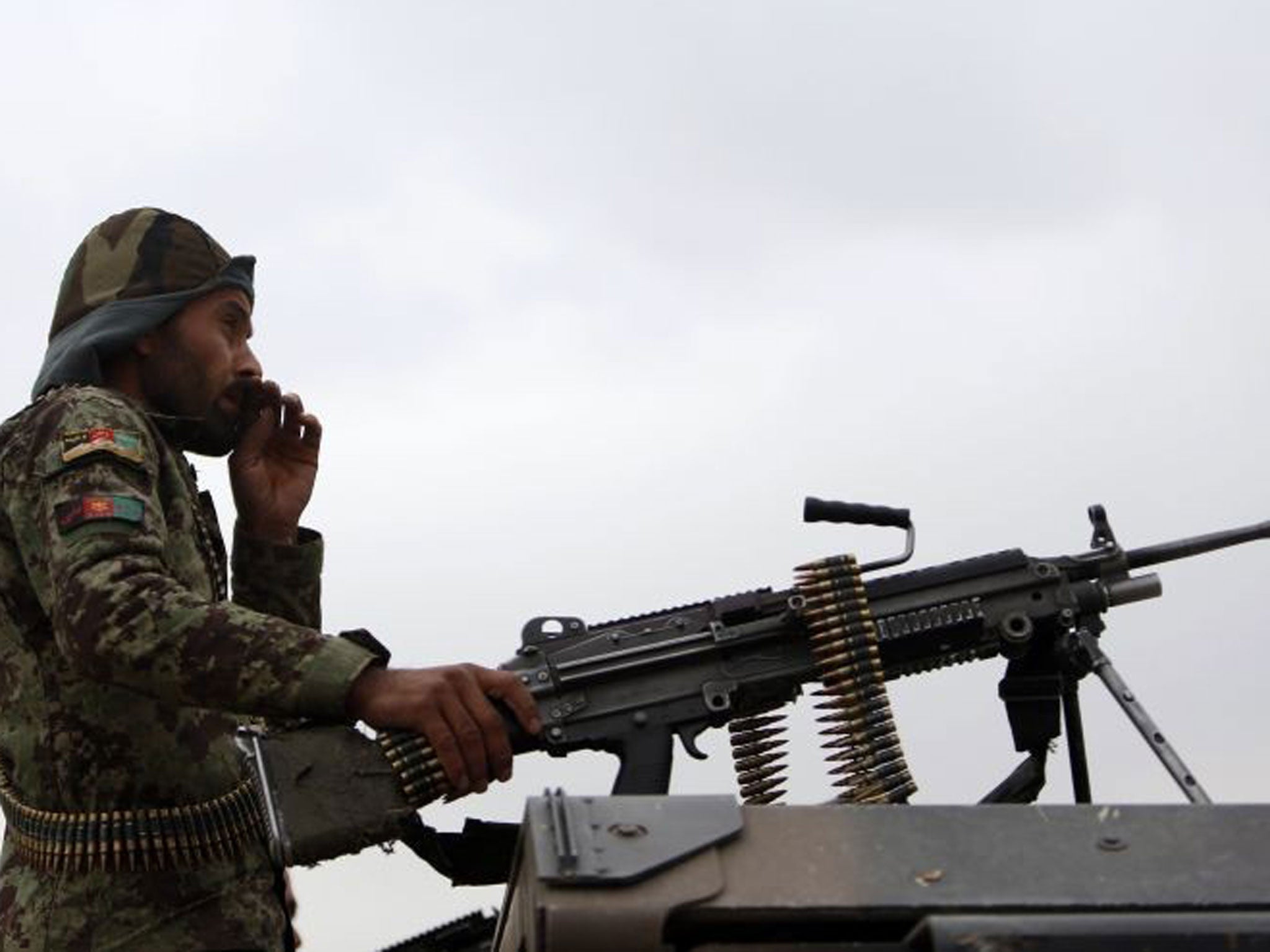 An Afghan National Army soldier keeps watch near the site of a gunfight on the outskirts of Kabul October 26, 2013.