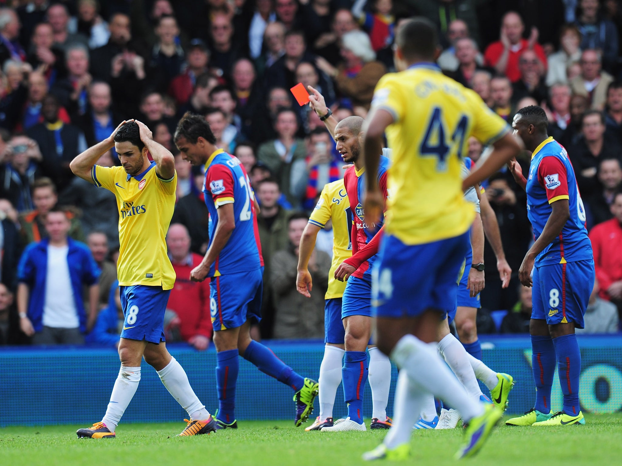 Mikel Arteta is shown a red card after bringing down Marouane Chamakh