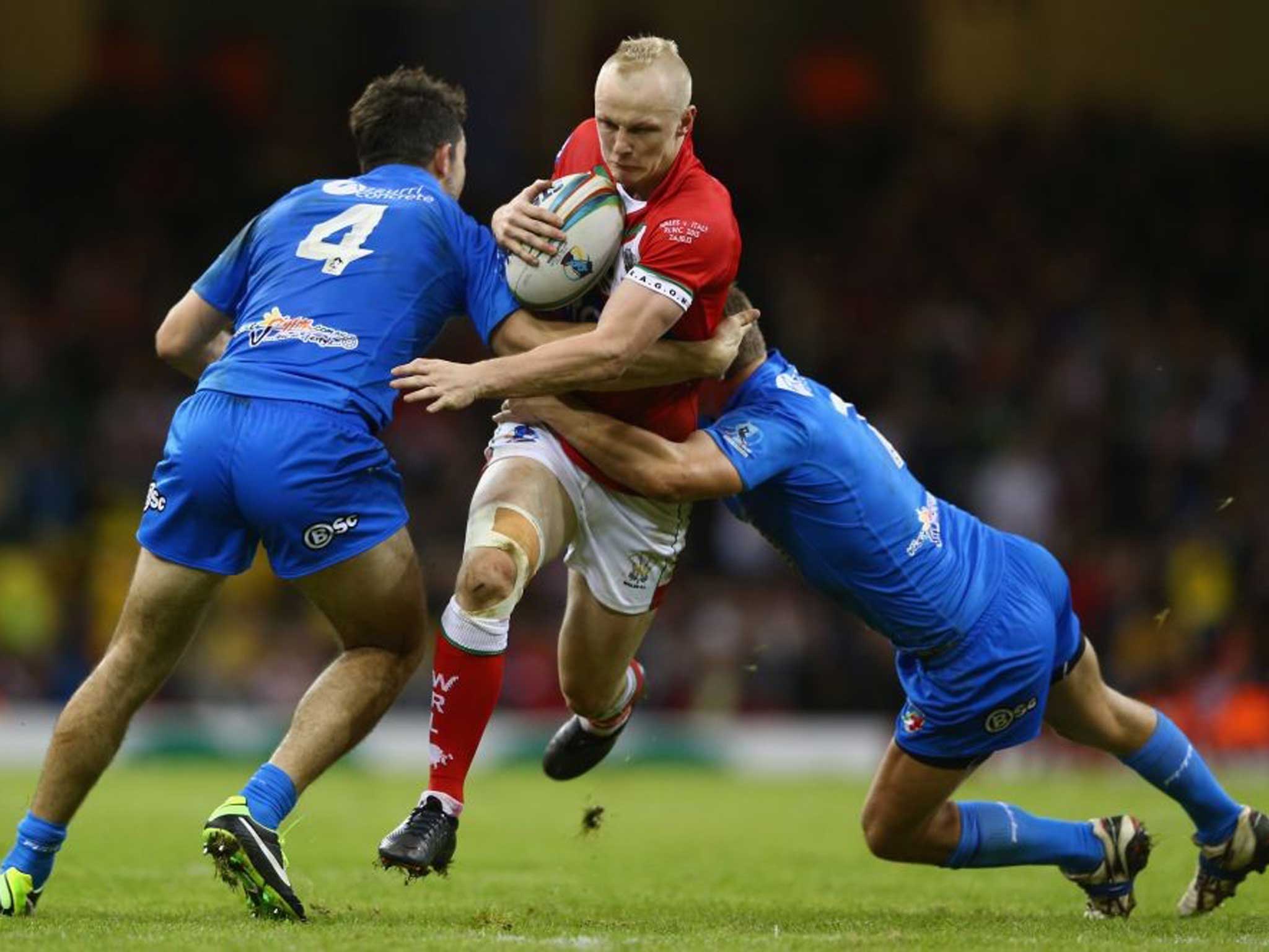 Rhys Evans is tackled by the Italians Ryan Ghietti (R) and Aidan Guerra (L) during the Rugby League World Cup Inter group match