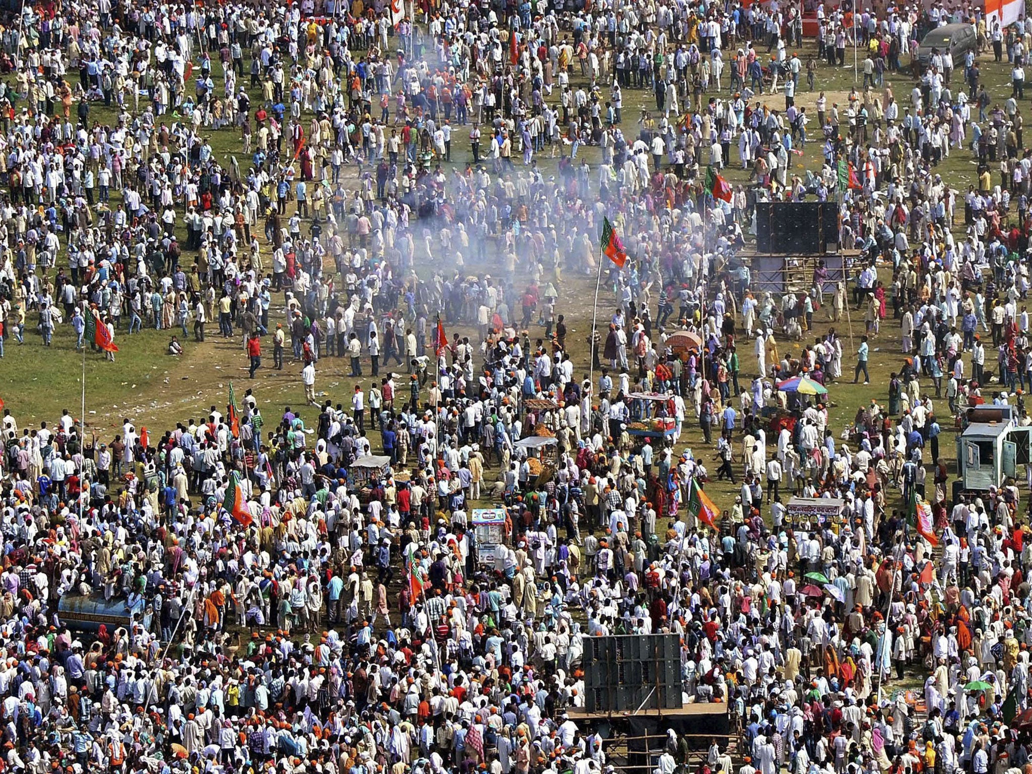 Plumes of gray smoke swirl above the crowd after one of a series of small bombs exploded near the venue of a rally by India's main opposition Bharatiya Janata Party (BJP) in Patna, India. A series of small bomb blasts killed some people and injured dozens just hours before a campaign rally by BJP's prime ministerial candidate Narendra Modi