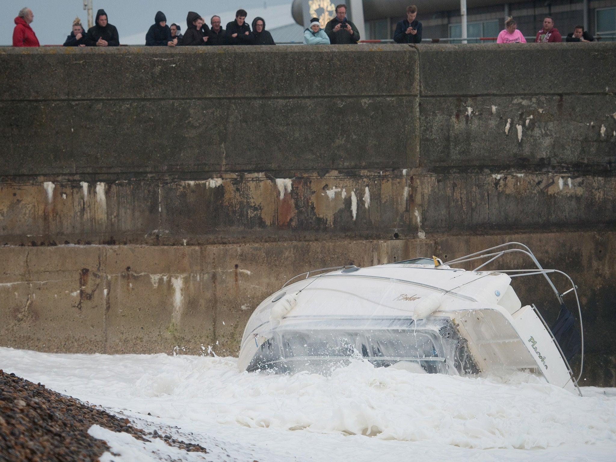 A boat is dragged from its mooring on the beach and destroyed by large waves near Brighton Marina, in southern England