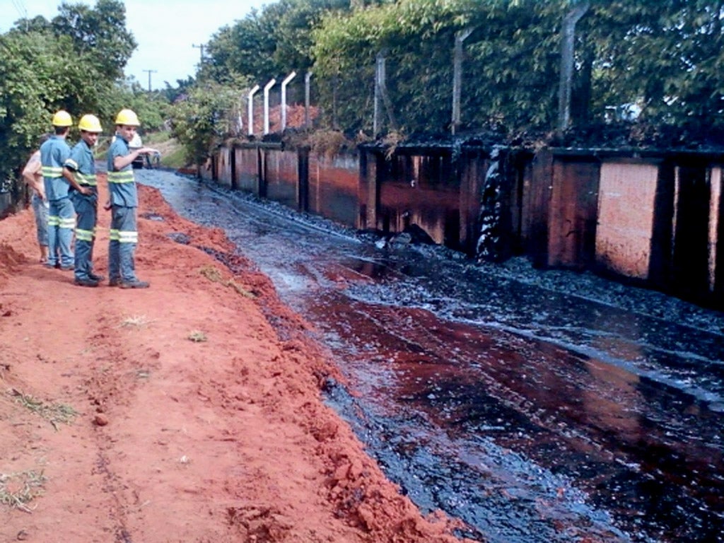 Workers look on bemused by the river of caramel in Santa Adelia