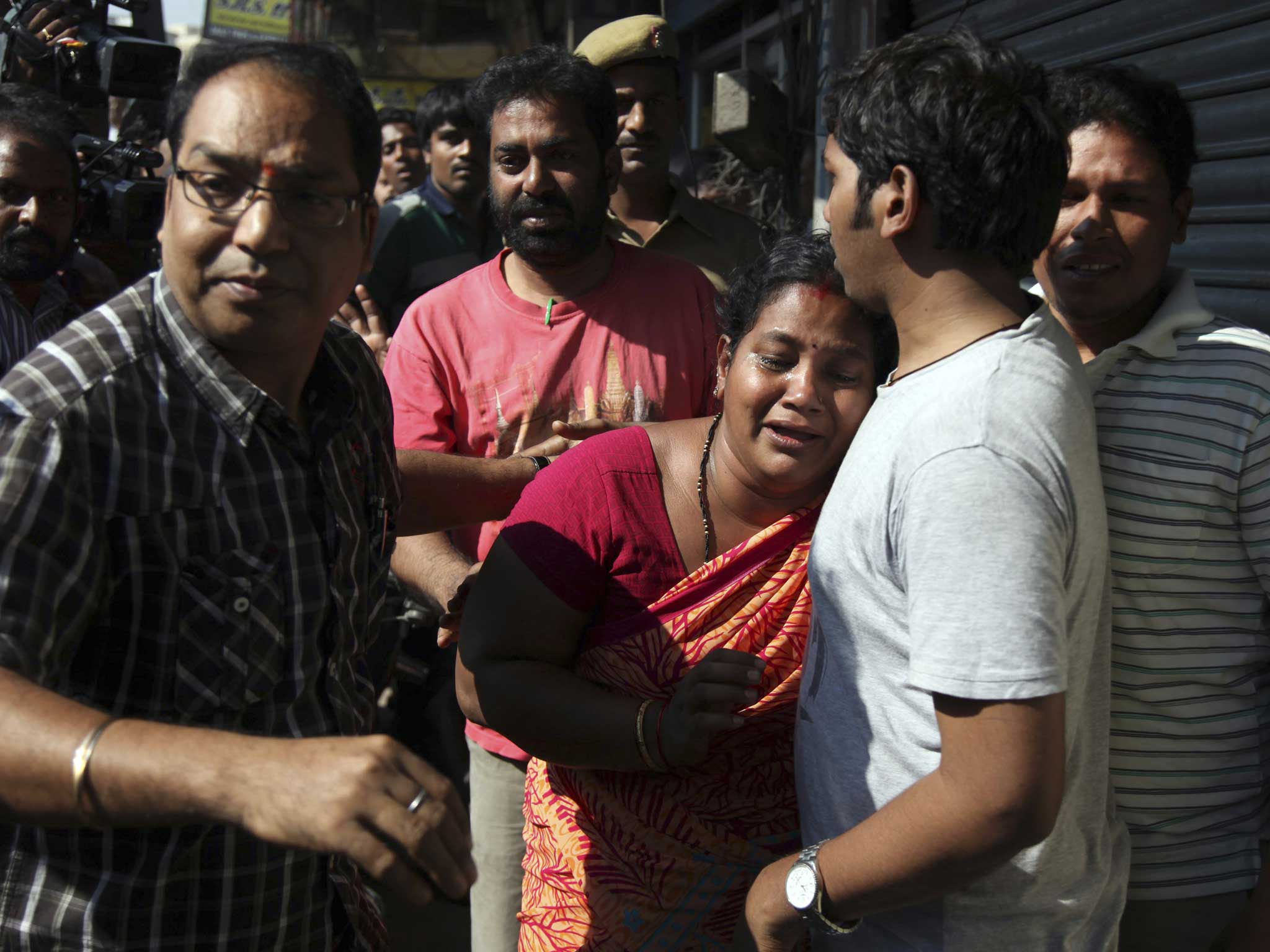 Relatives of passengers wait outside the office of the private bus operator, Jabbar Travels in Hyderabad