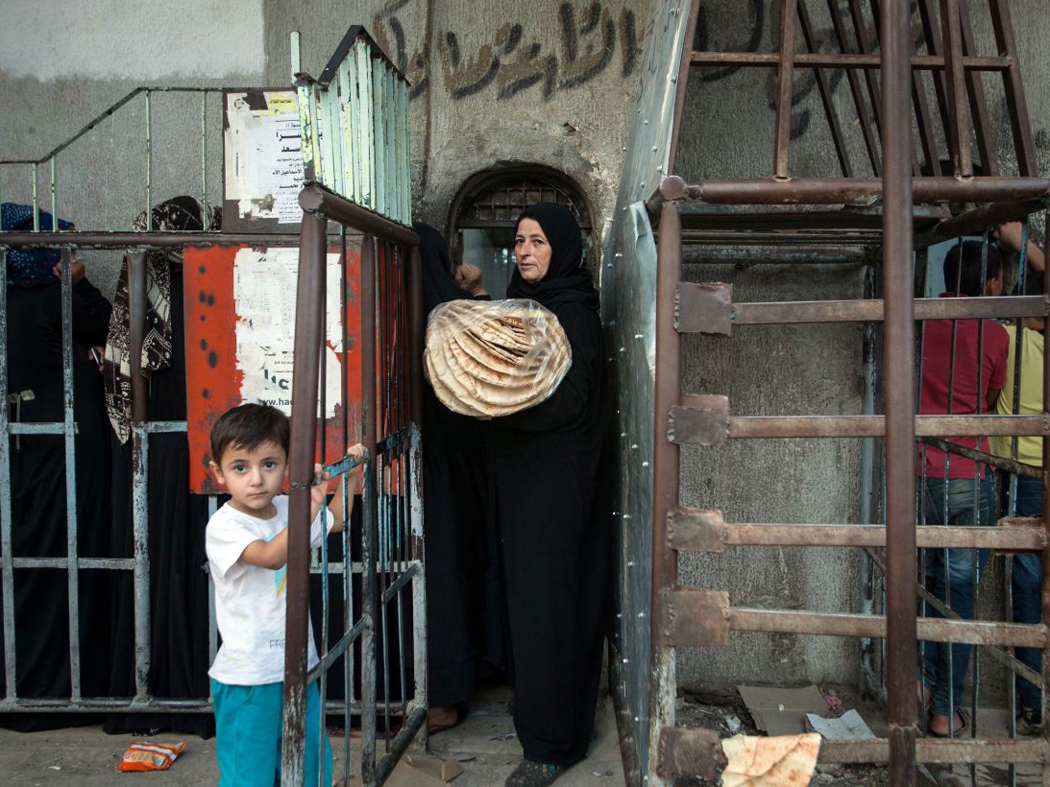 A Syrian woman carries bread from a bakery run by the Islamic rebel group ‘Ahrar Al-Sham’ amid claims the Assad regime has stopped aid getting through leaving residents to fend for themselves or starve