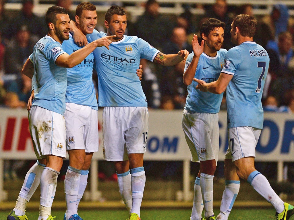 Manchester City players celebrate Edin Dzeko's goal and their progression through to the next round of the competition