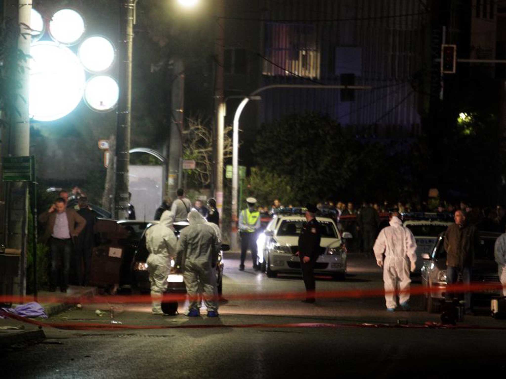 Police officers at the scene of the shooting, outside the local branch of the Golden Dawn party at the northern Athens suburb of Neo Iraklio