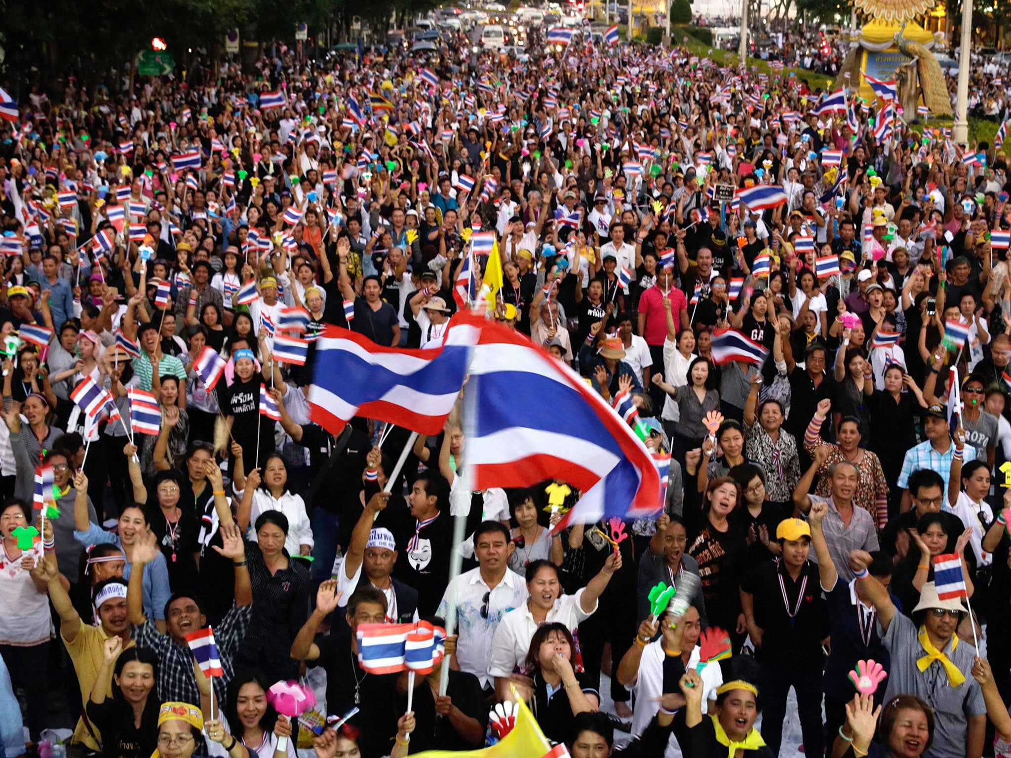 Anti-government protesters wave Thai flags during a rally against a controversial Amnesty bill that passed in Parliament. Protesters fear if the law is passed it could whitewash all crimes for which the former leader Thaksin Shinawatra was convicted