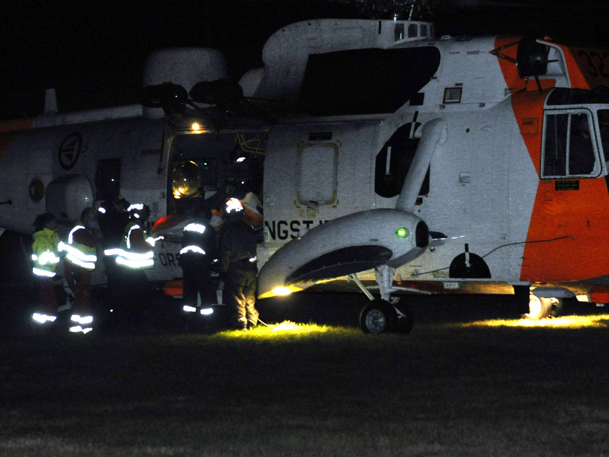 Emergency personnel surround a helicopter near the site of a bus hijacking in Aardal