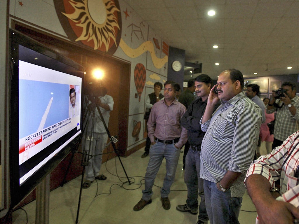 People gather round a television set to see the launch