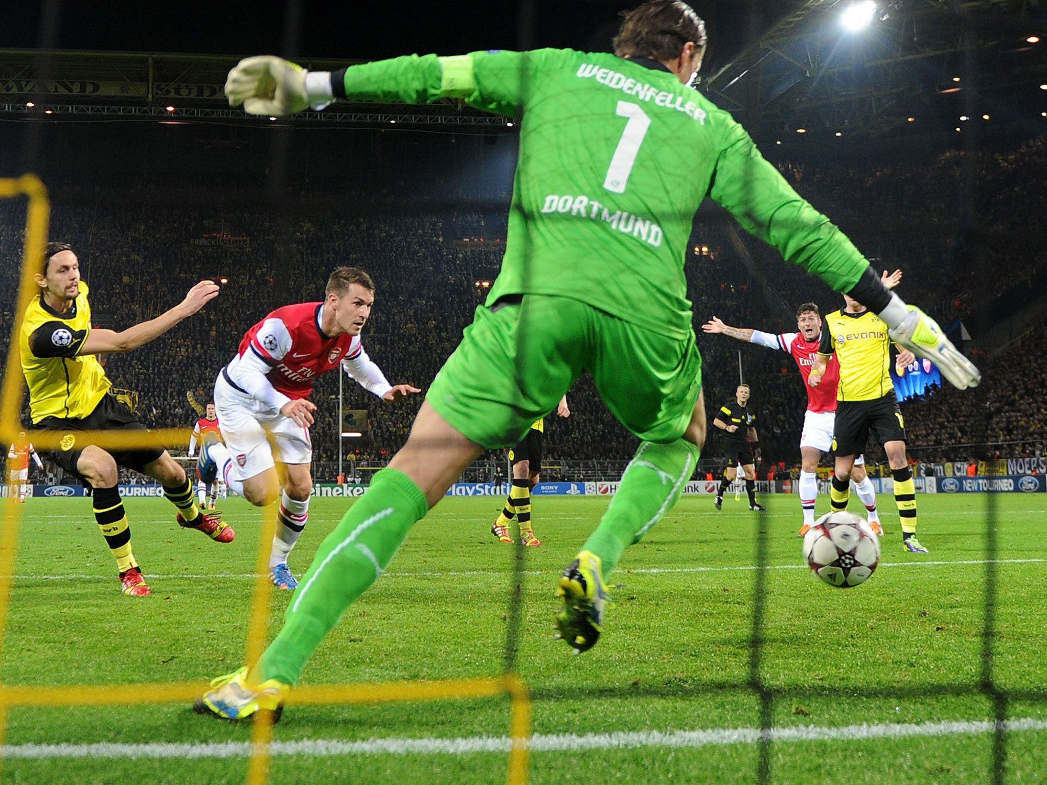 Aaron Ramsey (2nd L) of Arsenal scores the opening goal past Roman Weidenfeller of Dortmund during the UEFA Champions League Group F match between Borussia Dortmund and Arsenal at Signal Iduna Park