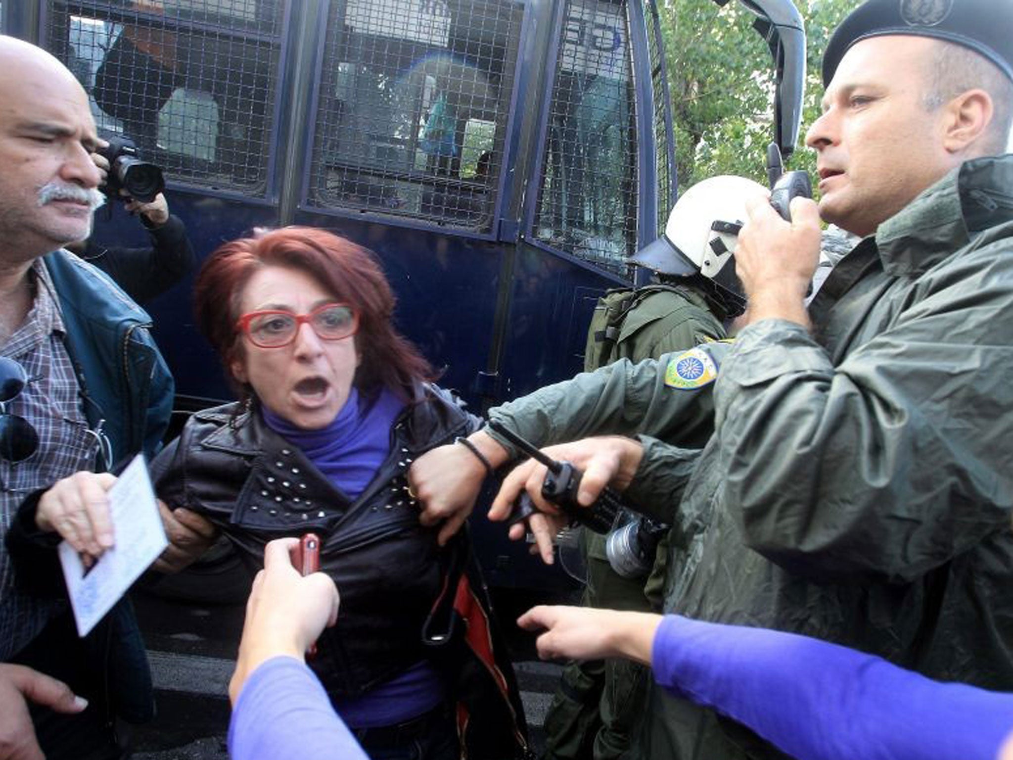 Main opposition party SYRIZA MP Ioanna Gaitani (C) argues with a police officer at the Greek Public Broadcaster (ERT)