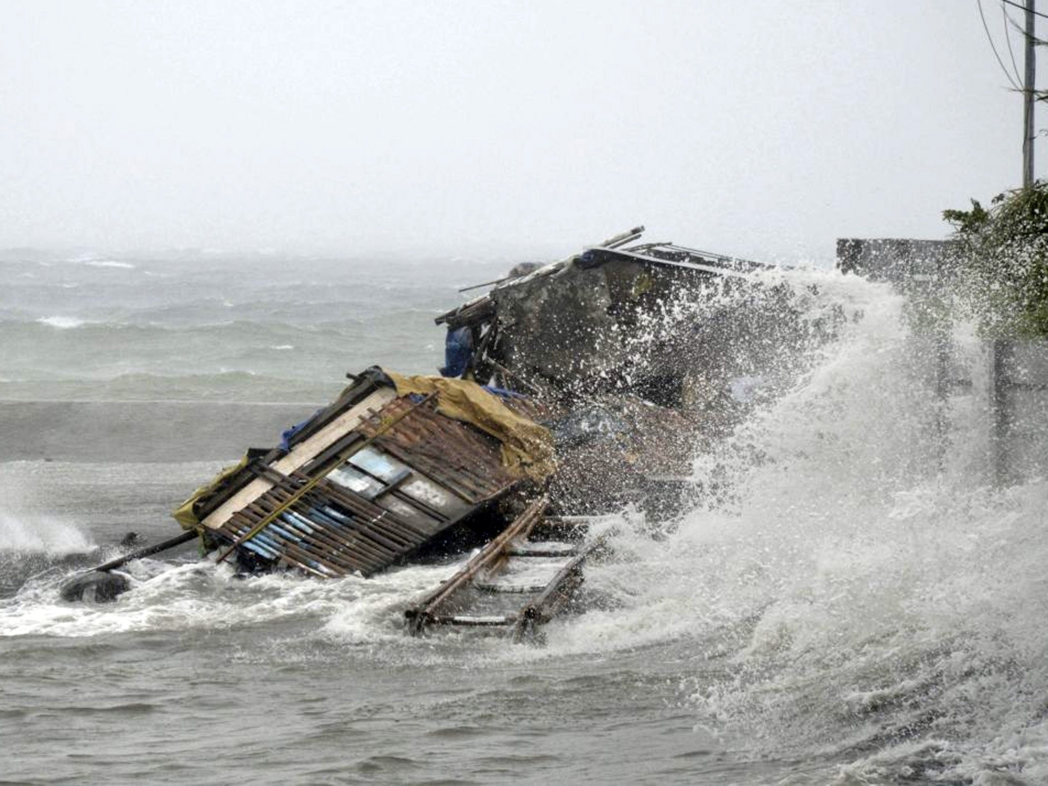 A house is engulfed by the storm surge brought about by typhoon Haiyan that hit Legazpi city, Albay province