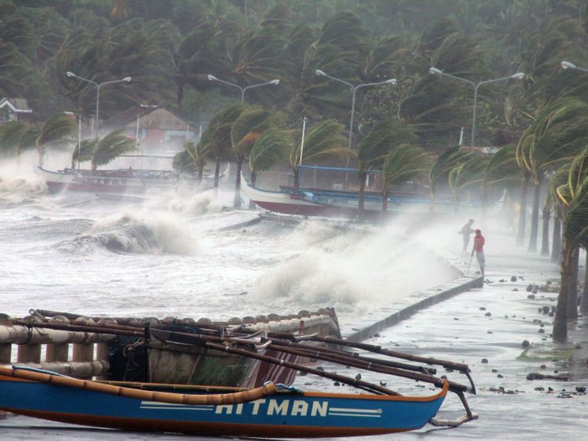 Residents stand along a sea wall as high waves pounded them amidst strong winds as Typhoon Haiyan hit the city of Legaspi, Albay province, south of Manila