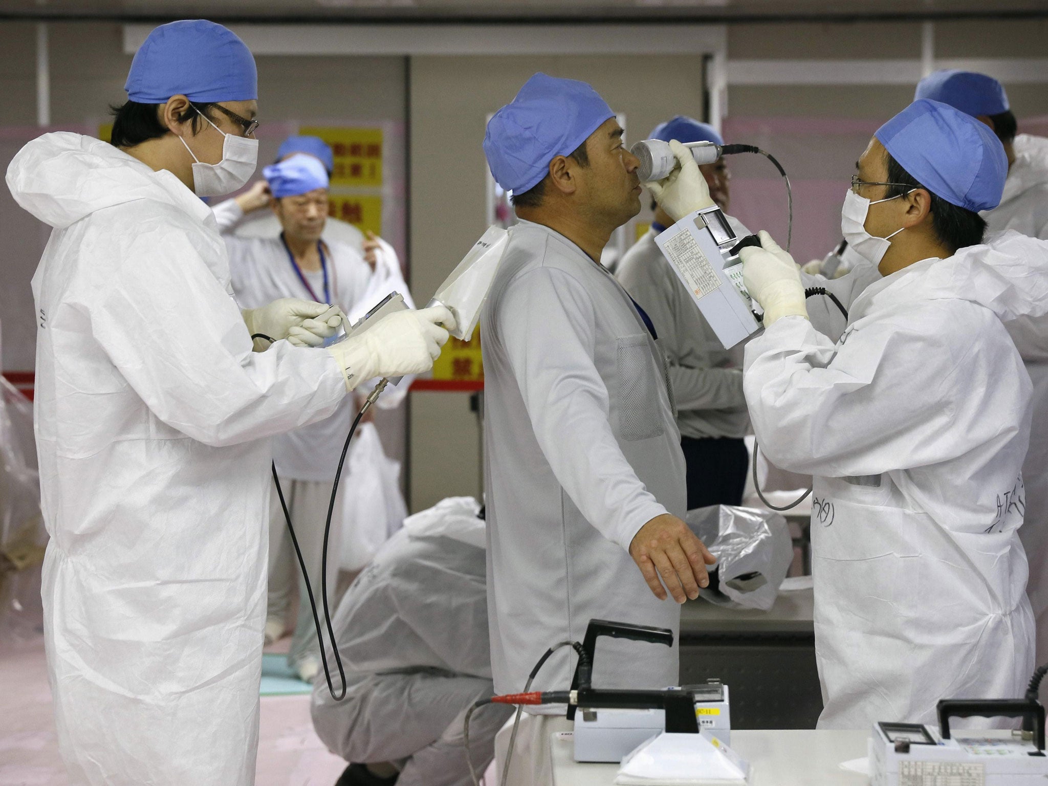 Workers are checked for radiation at the Fukushima Daiichi nuclear power plant