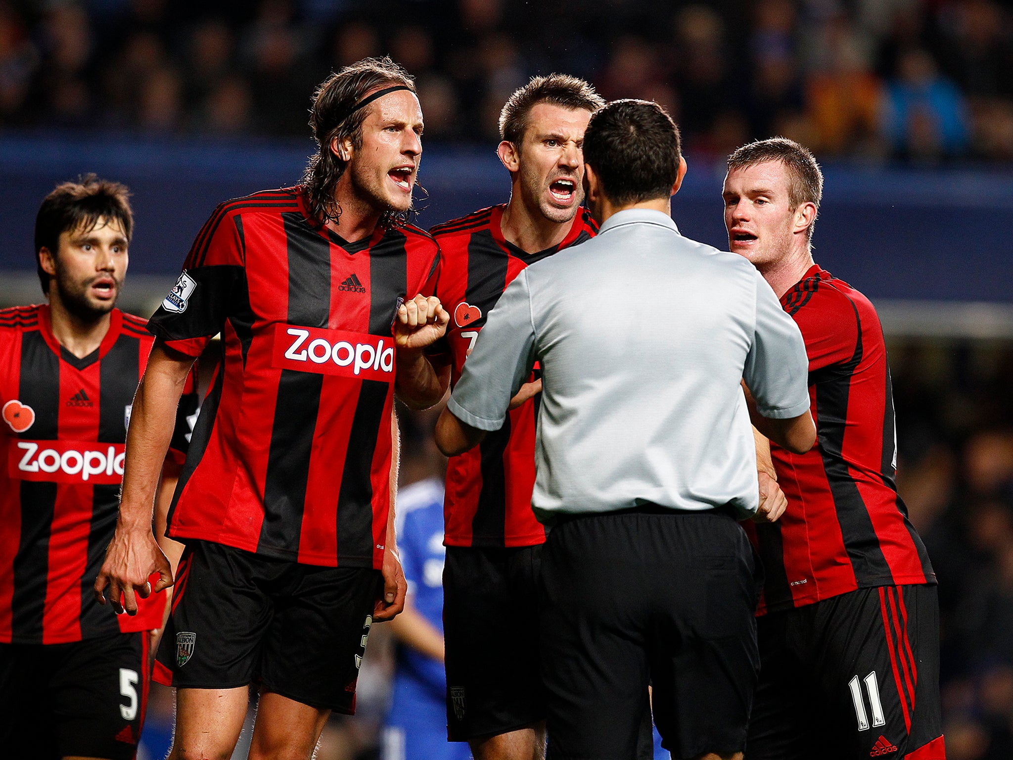 West Brom players protest as Andre Marriner awards Chelsea a last-gasp penalty.