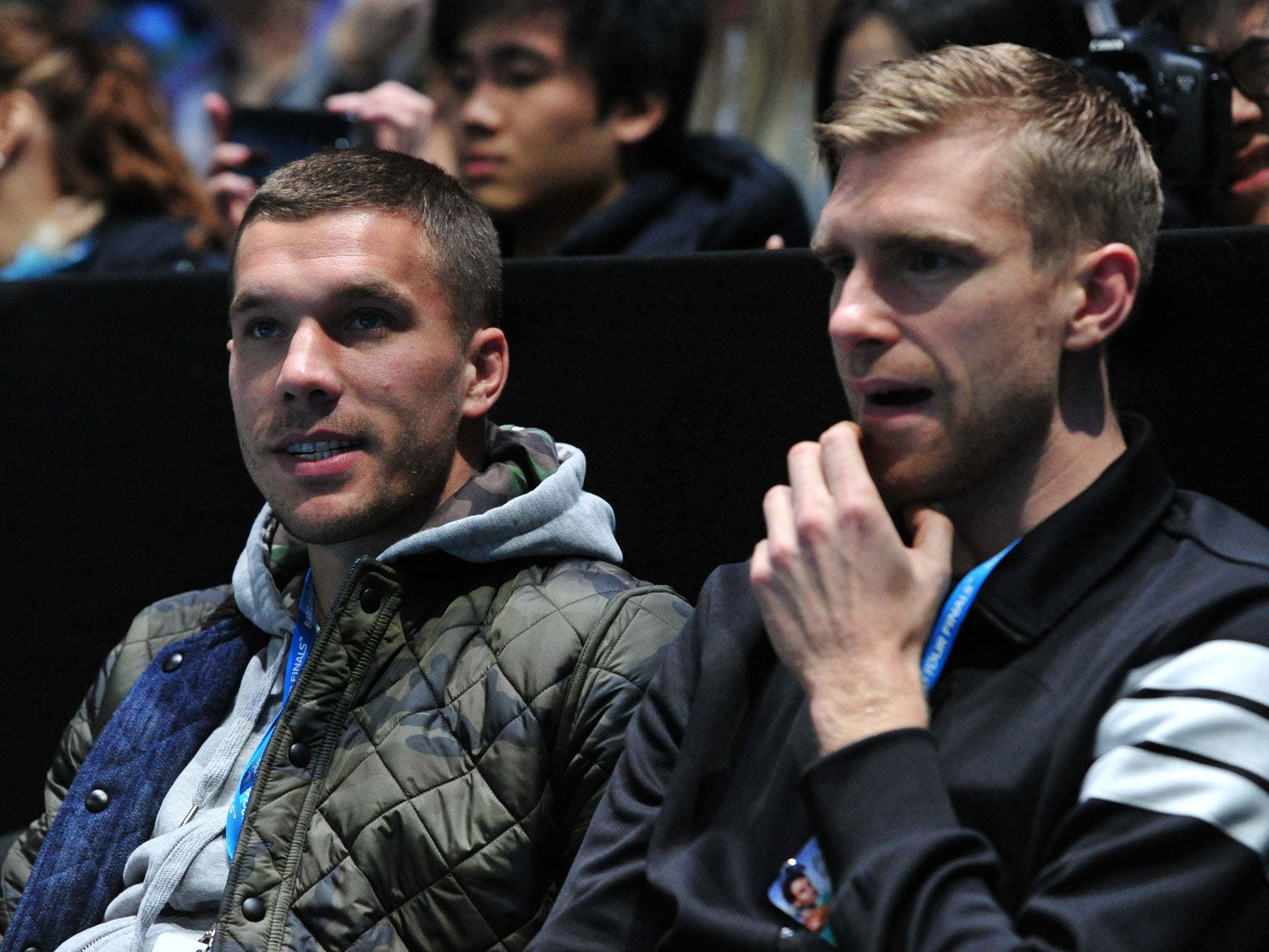 Lukas Podolski (left) and Per Mertesacker watch the tennis at the O2