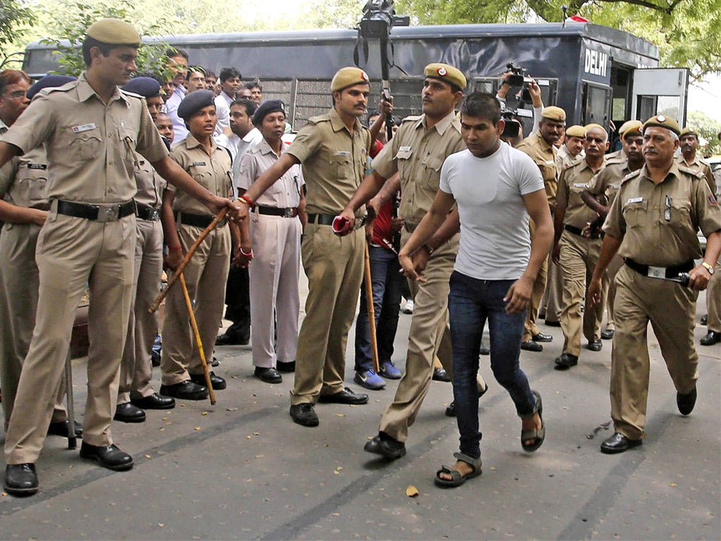 Strict security surrounds Vinay Sharma (wearing white T-shirt), one of the four men sentenced to hang for fatally raping a young woman on a bus as he makes his way to court in Delhi