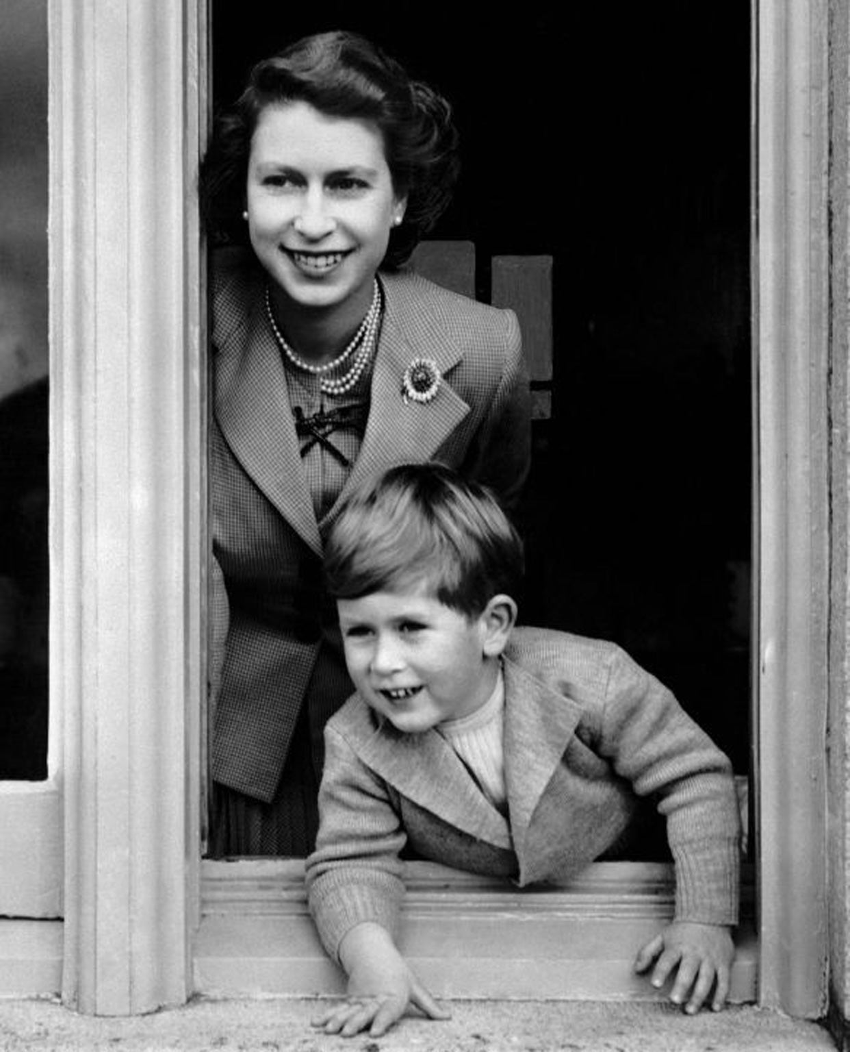 14 November 1952: Prince Charles on his fourth birthday, leaning from a window with the Queen