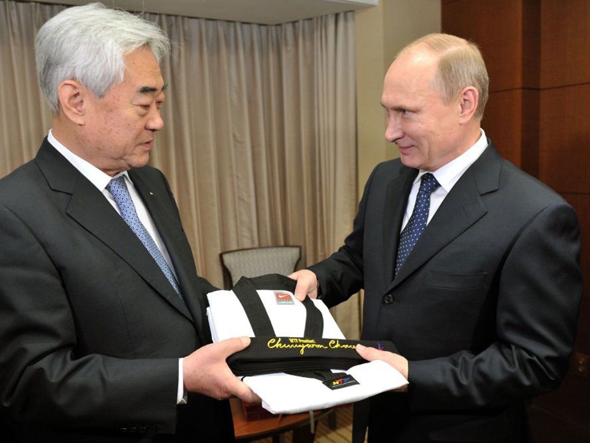 World Taekwondo Federation president Choue Chung-won gives an honorary taekwondo black belt and uniform to Russian President Vladimir Putin in Seoul, South Korea