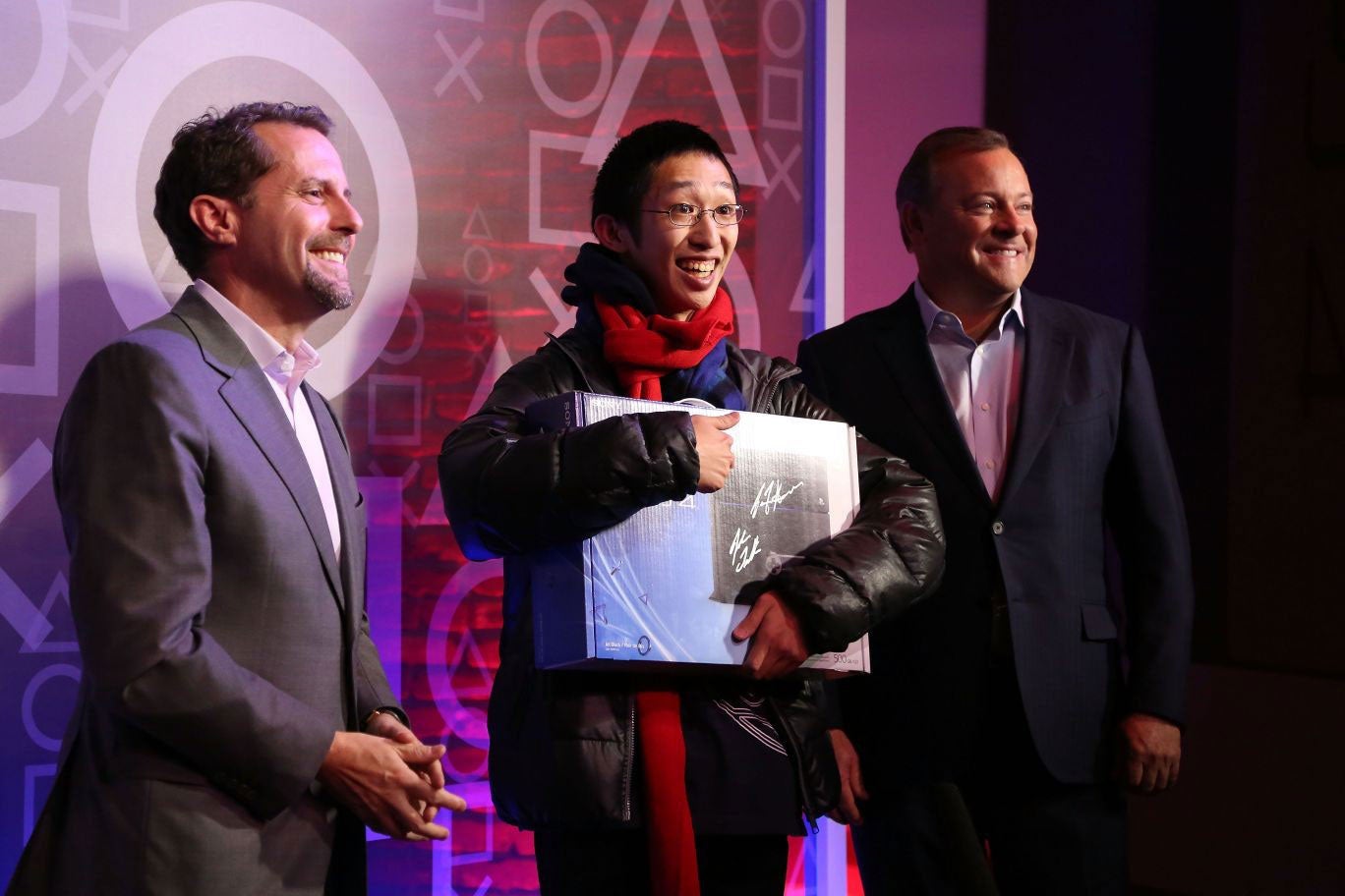 Andrew House, President and CEO of Sony Computer Entertainment and Jack Tretton, President and CEO Sony Computer Entertainment America, present 24-year-old Joey Chiu of Brooklyn with the first of 444 PS4s to be sold at the PlayStation 4 North American Official Launch event presented by Sony Entertainment Network at The Standard, Highline