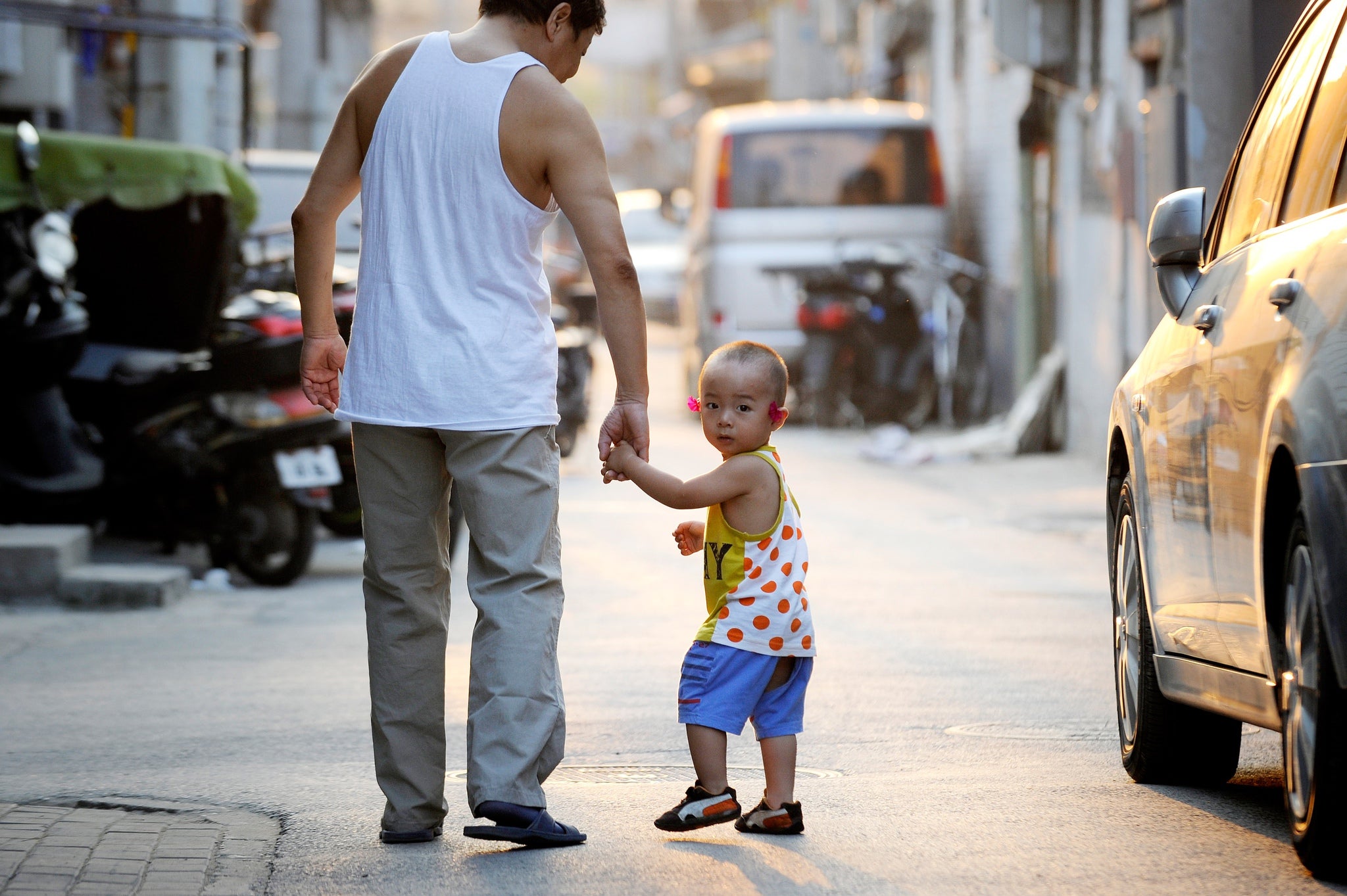 A family make their way along a lane in Beijing