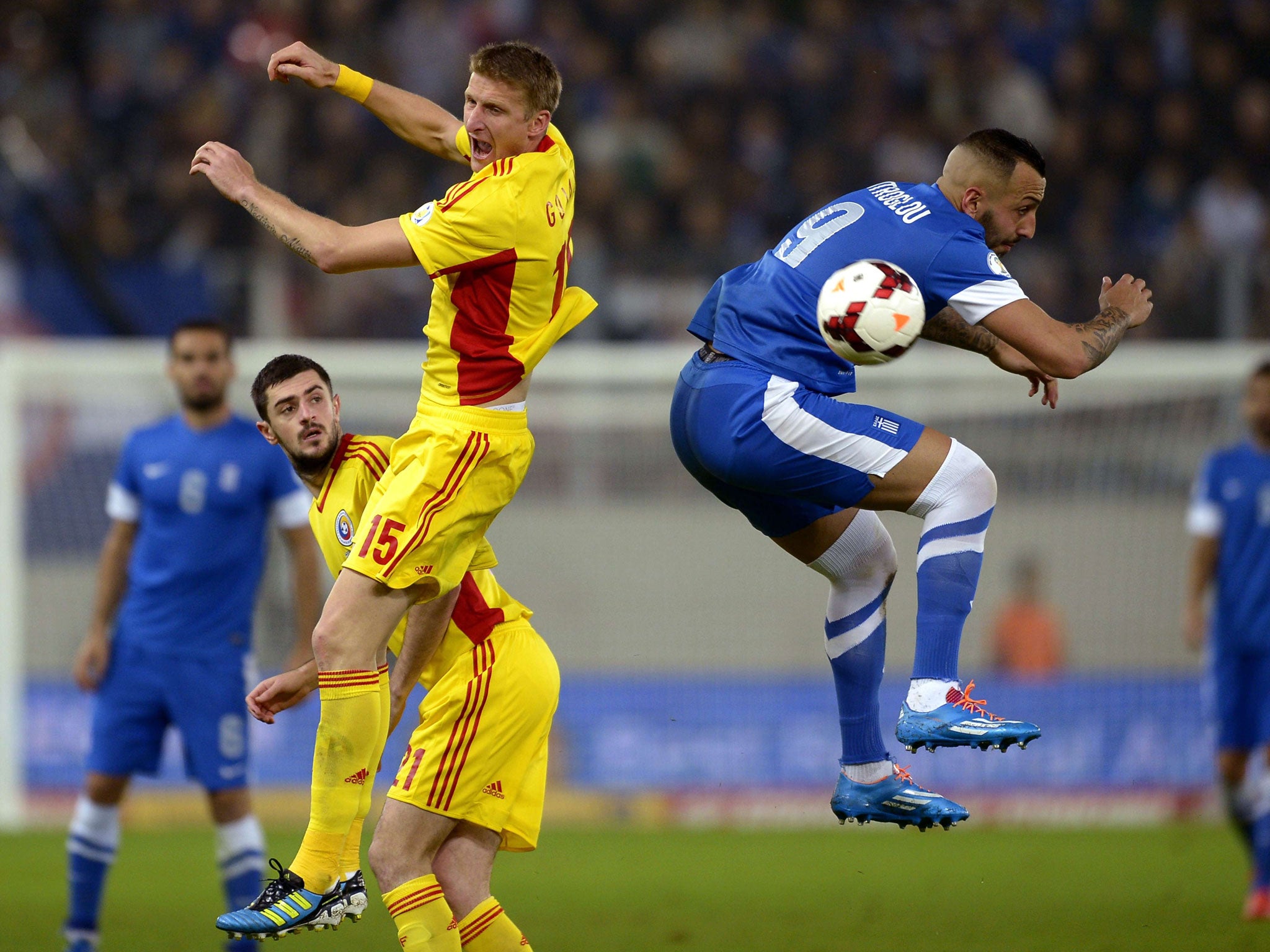 Greece's Kostas Mitroglou vies with Romania's Dorin Nicolai Goian AFP/Getty