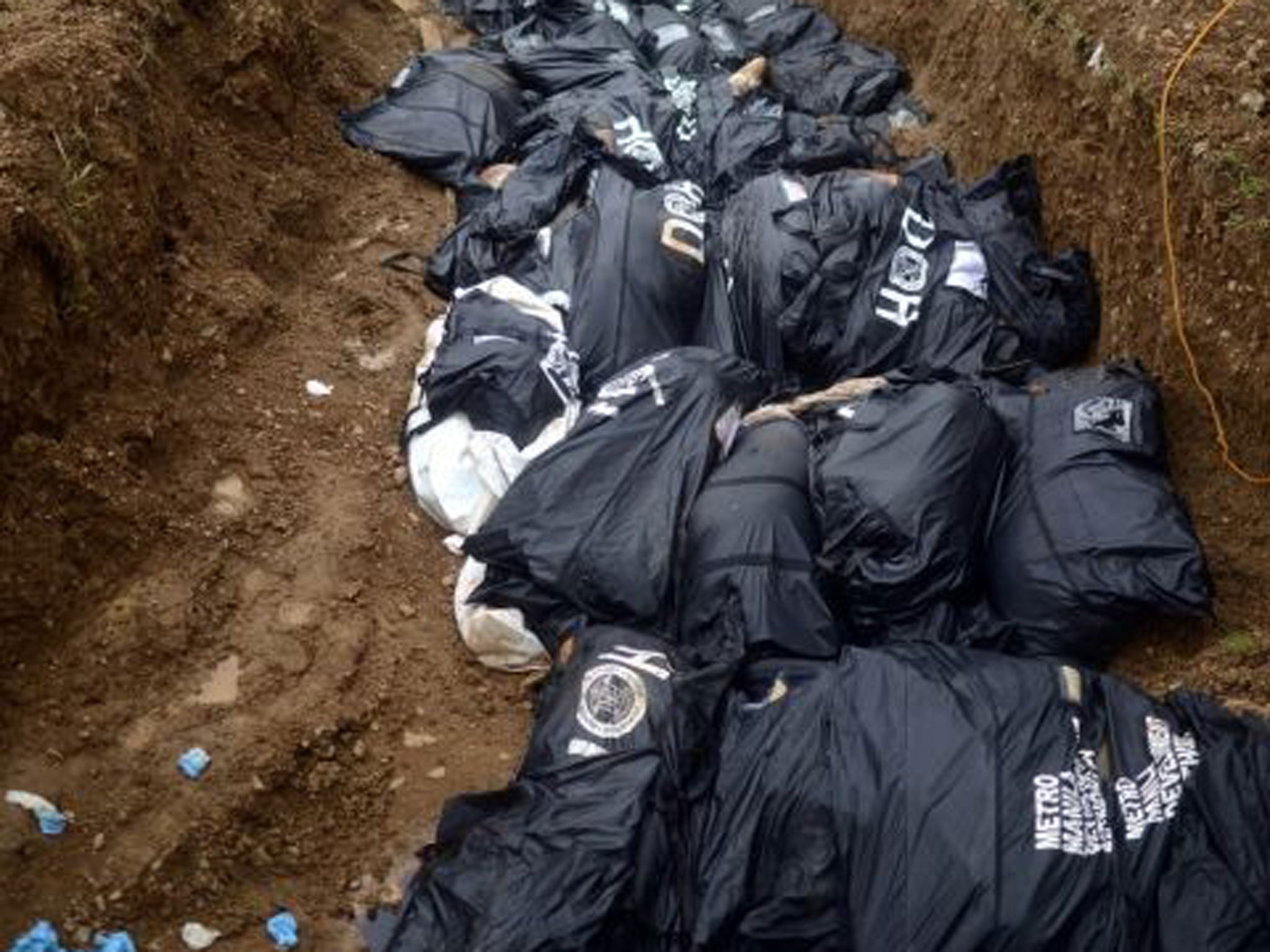 Devastation: Tacloban victims have been buried in a mass grave to stop disease spreading