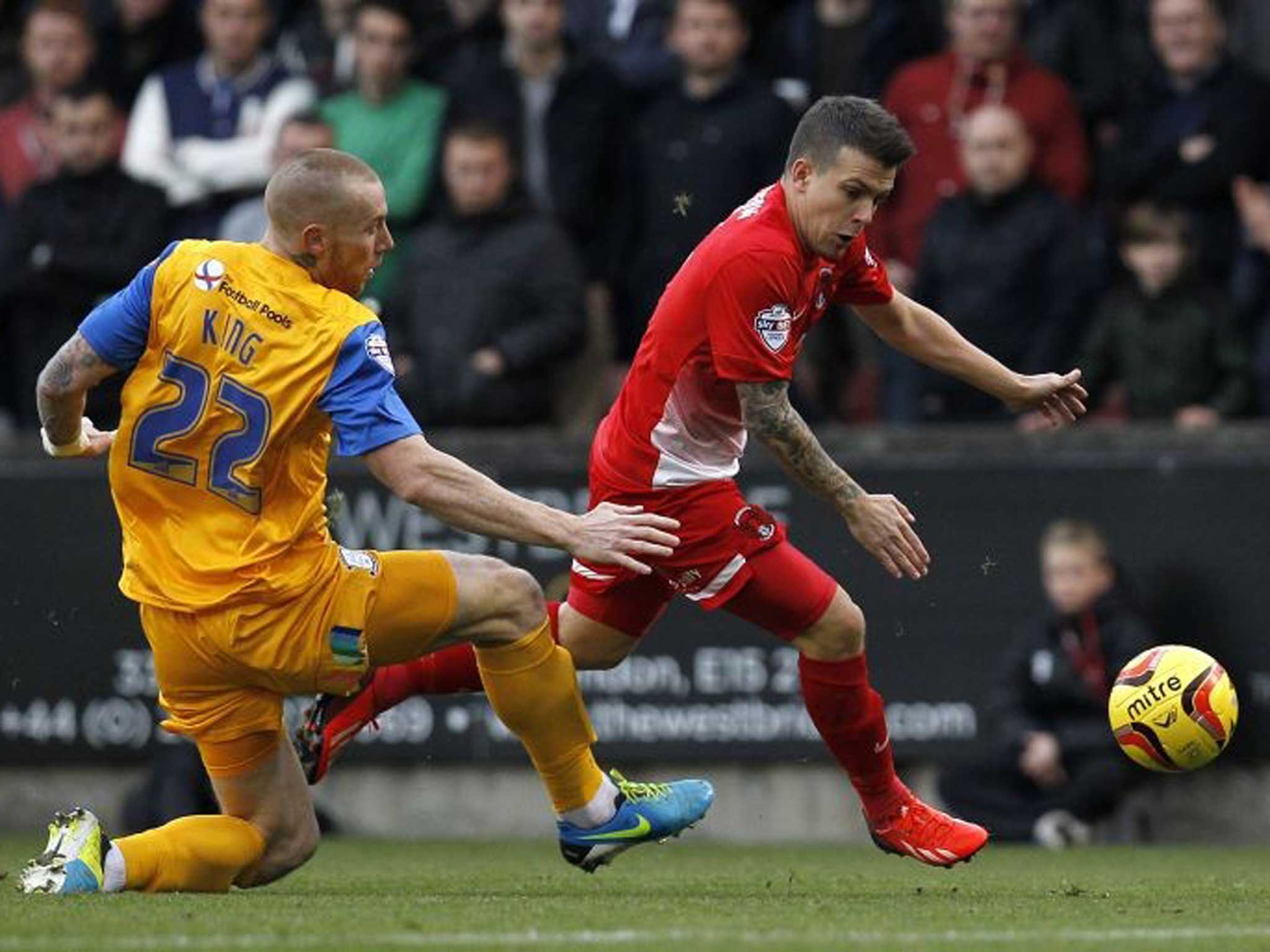 Dean Cox of Leyton Orient skips round Jack King of Preston