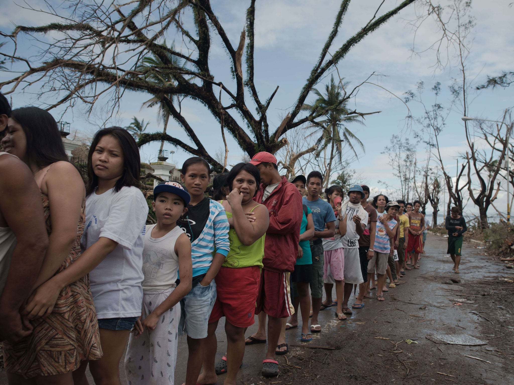 Typhoon victims queue for relief food outside Tacloban’s legislature