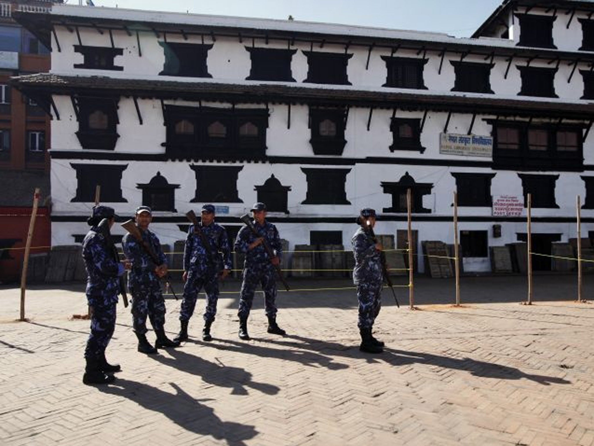 Nepalese policemen stand guard at a temporary polling booth space set by ropes and polls in Katmandu