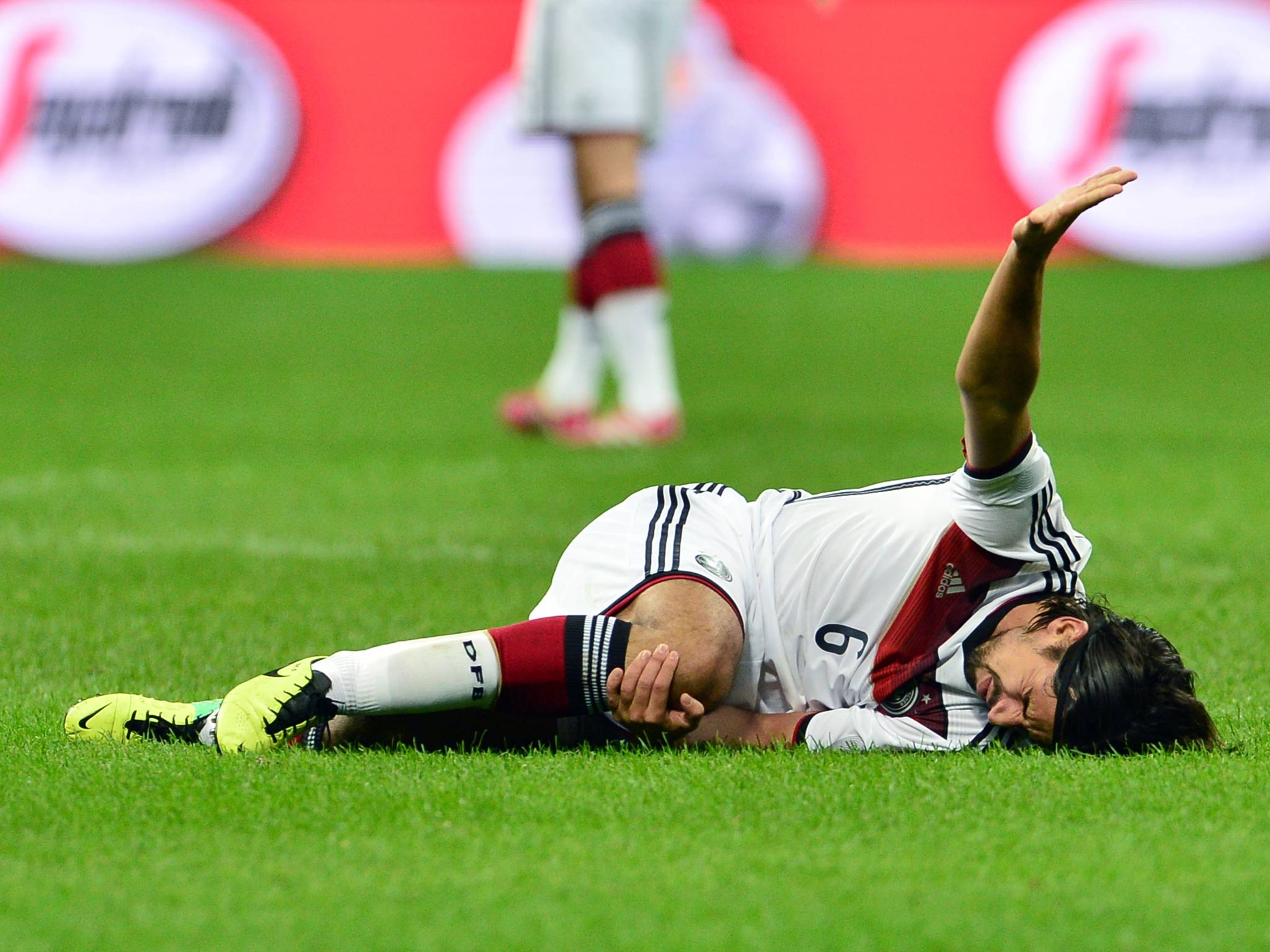 Sami Khedira of Germany calls for assistance after sustaining an injury against Italy