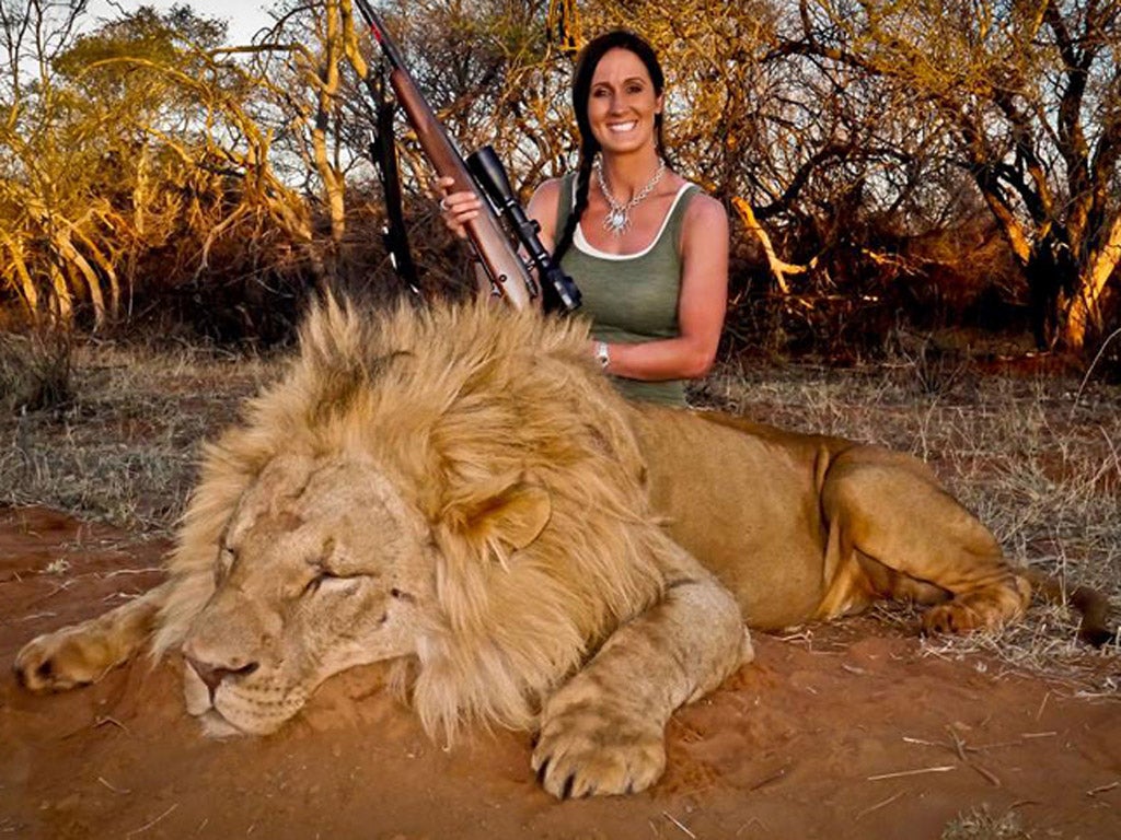 Melissa Bachman poses with a dead male lion in South Africa