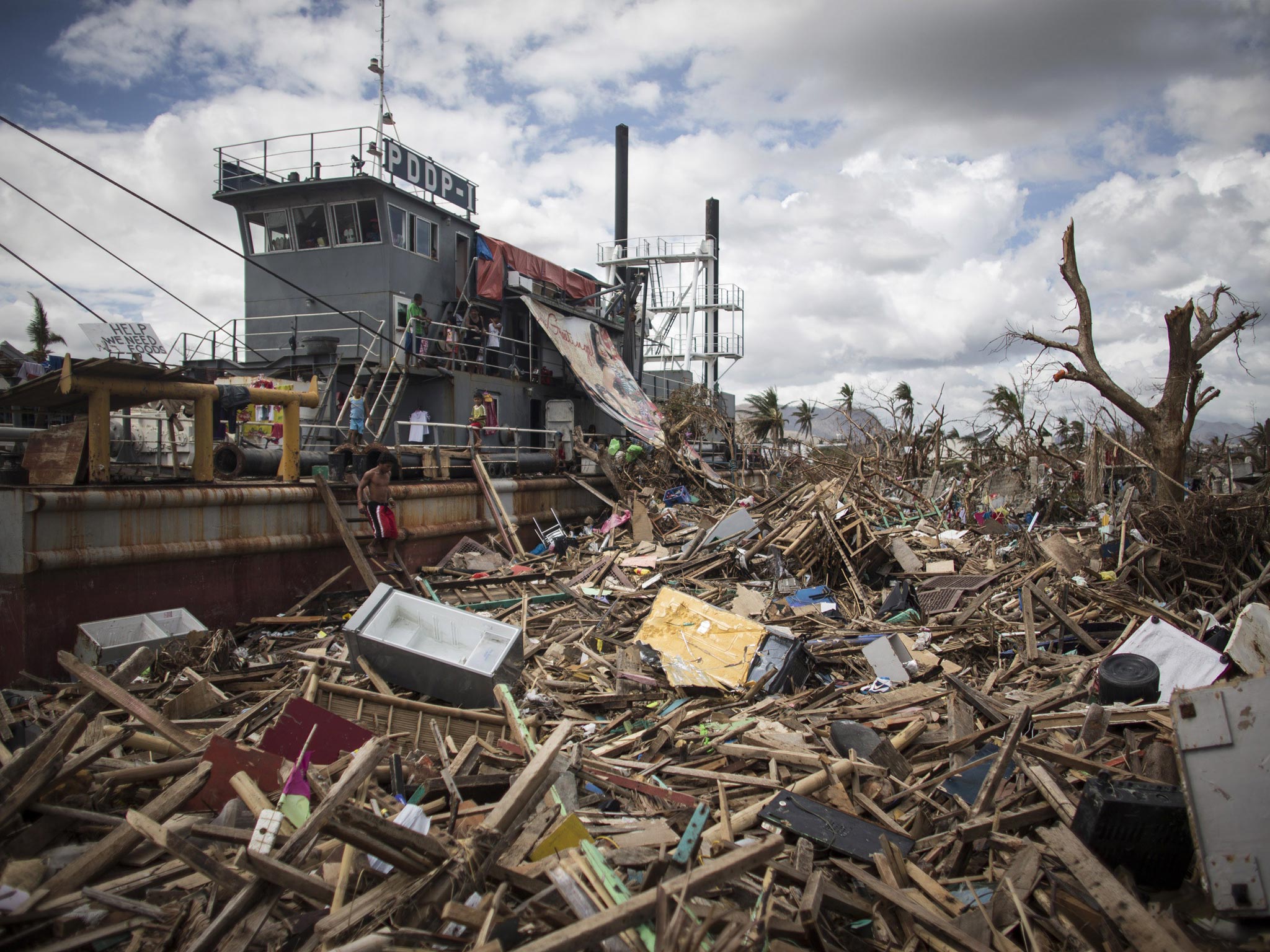 19 November 2013: A man walks down steps from a tanker that was washed ashore in a particularly badly damaged part of Tacloban during Typhoon Haiyan in Leyte, Philippines